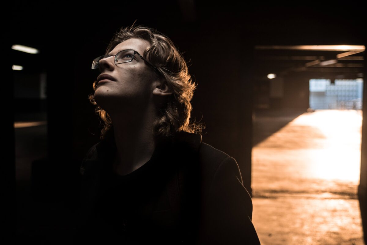 Portrait of a young man on a car park at sunset