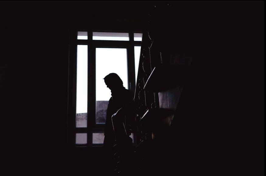 Silhouette of a woman on a staircase against a widow in Berlin