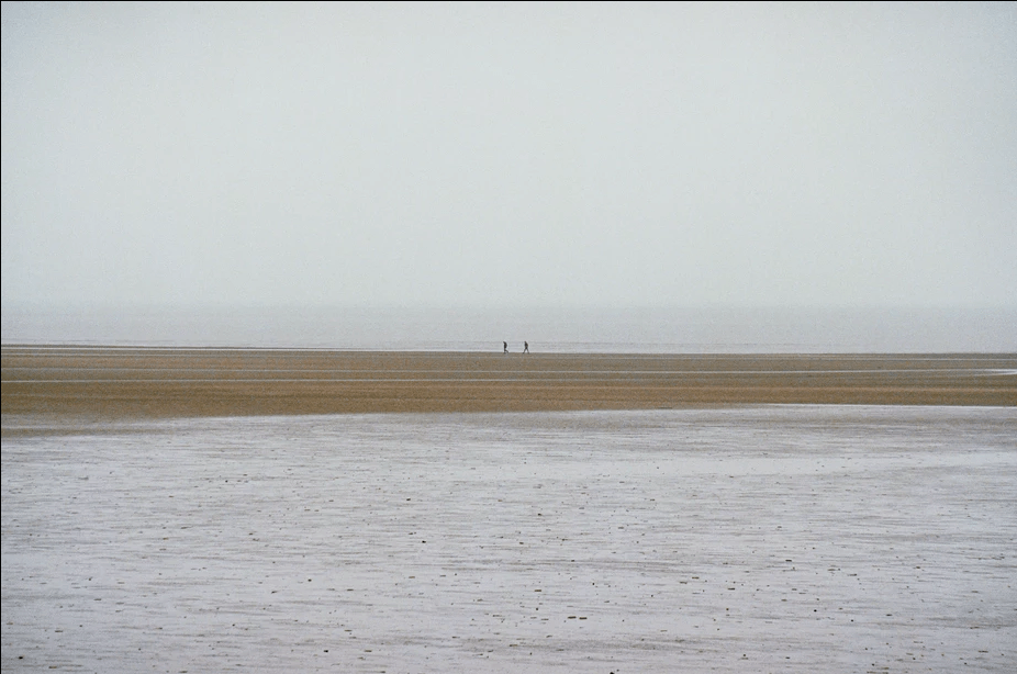 10 Best Ways To Improve Photography Skills. Fedor Vasilev Photographer In Berlin two people walking on a beach far away. Shot on a prime lens