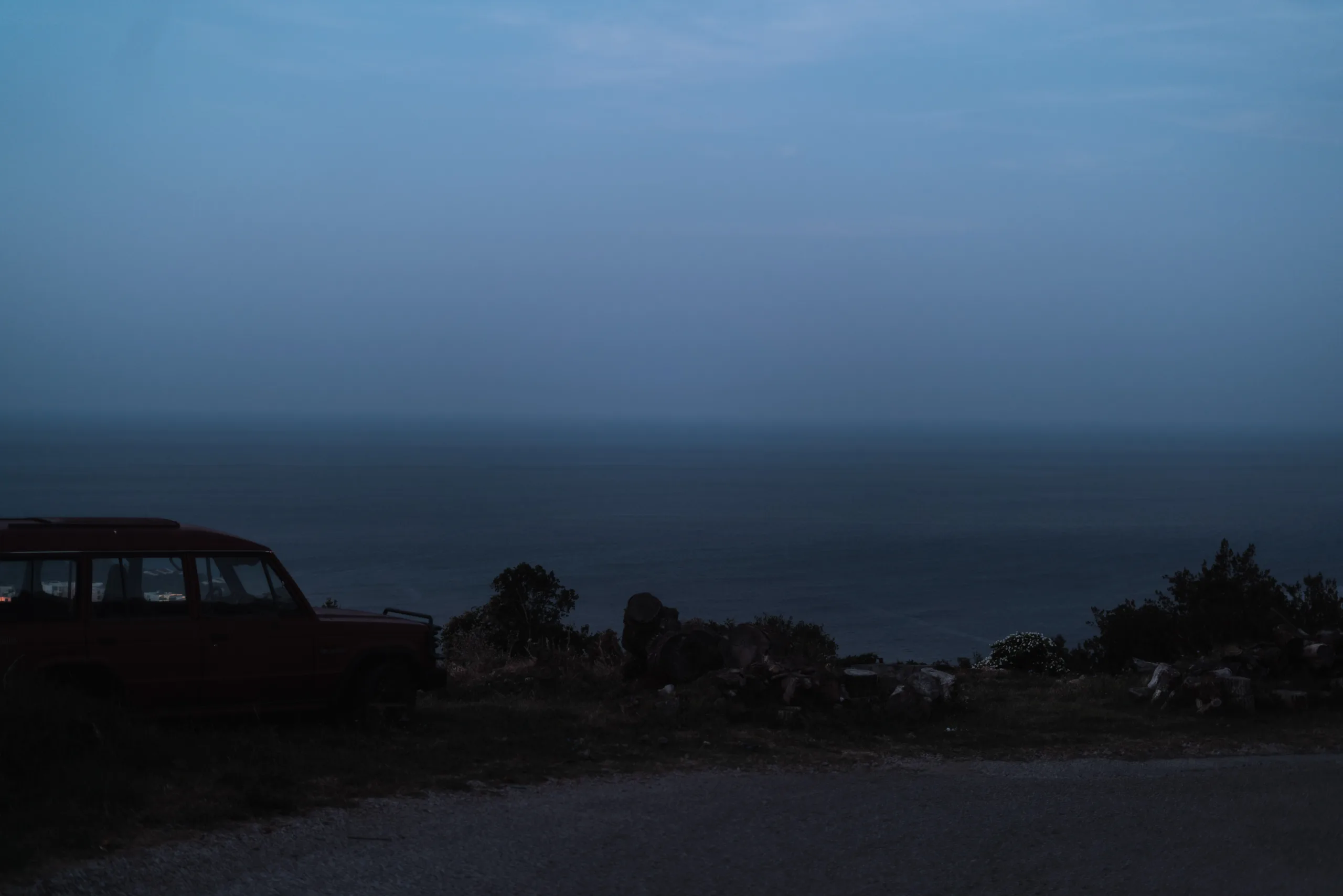 What cinematic photography means to me Fedor Vasilev Photographer In Berlin A car on a hill with the view over a sea at dusk