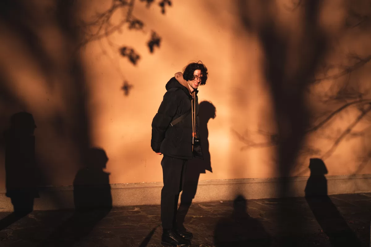 A young man surrounded by people's silhouettes in Vienna