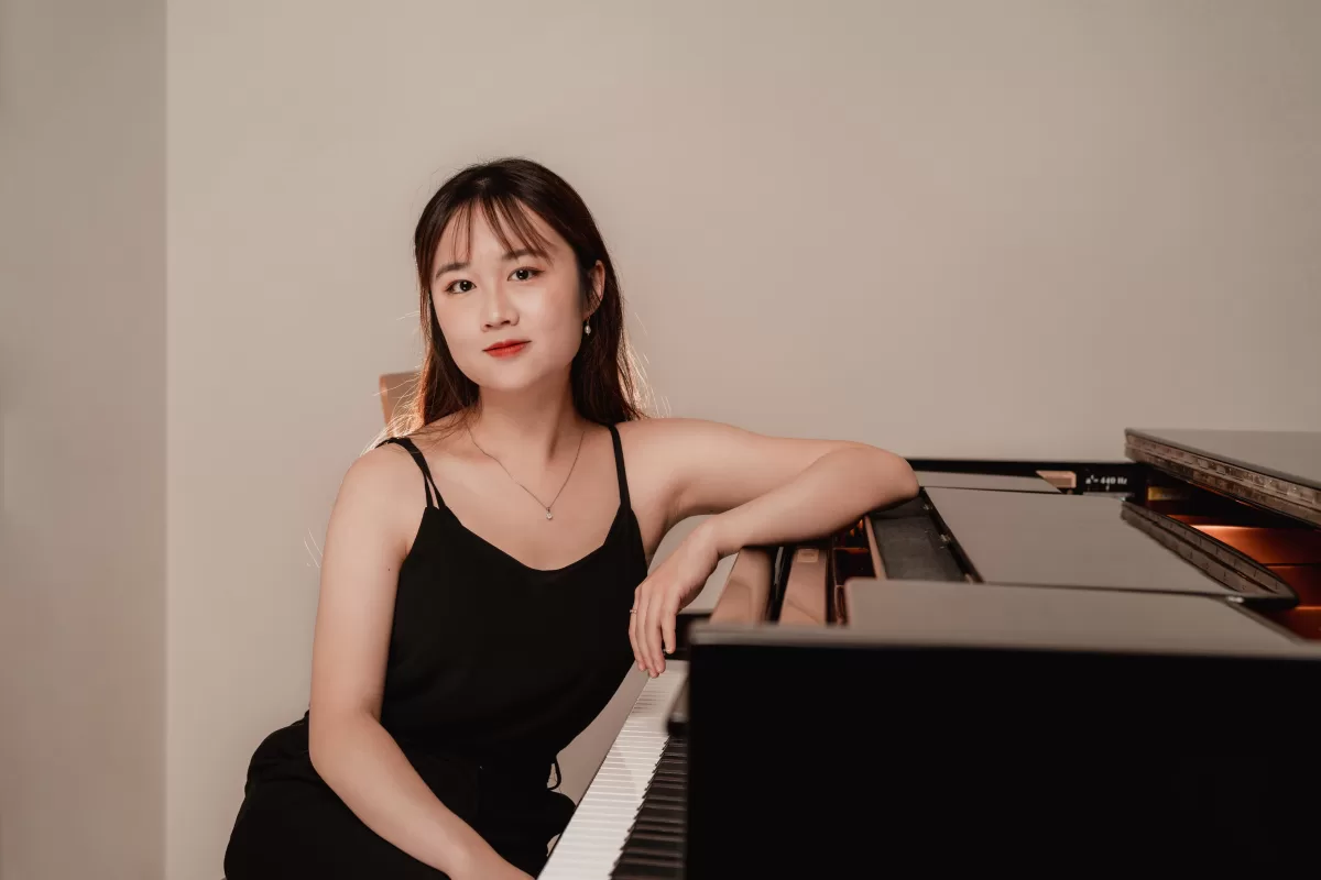 Pianist photoshoot in Vienna leaning on a piano