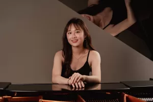 Pianist portrait photoshoot: example of a photo of a pianist leaning on a piano