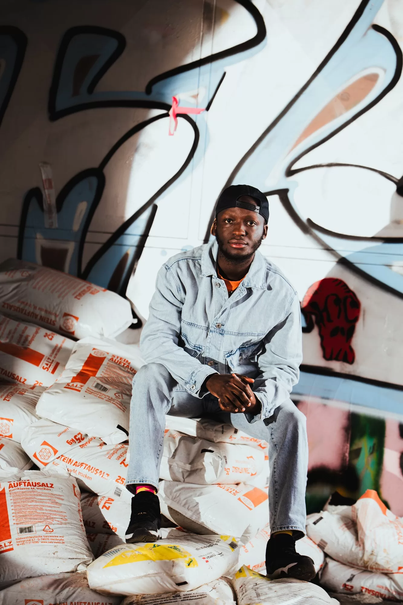 Man sitting on sacks with cement at an abandoned area