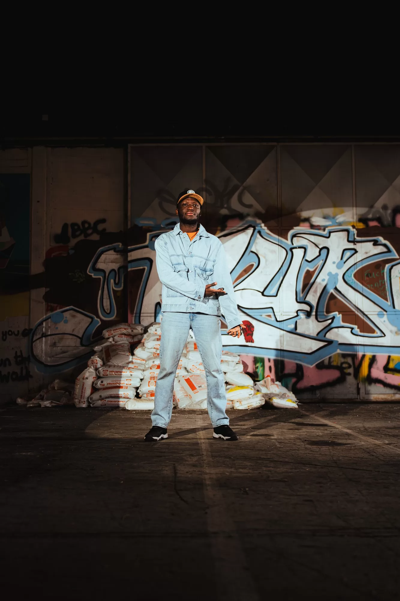 A portrait of a man in a grungy area with graffiti