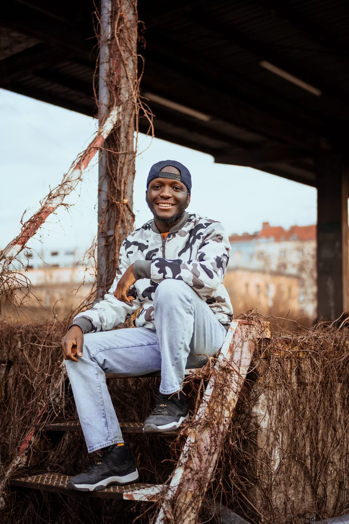 Portrait of a man sitting on stairs on an abandoned train stop