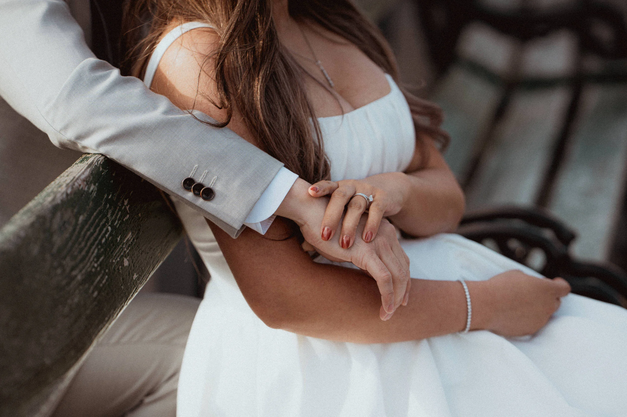 A man hugging a woman from behind on a park bench in Volksgarten in Vienna