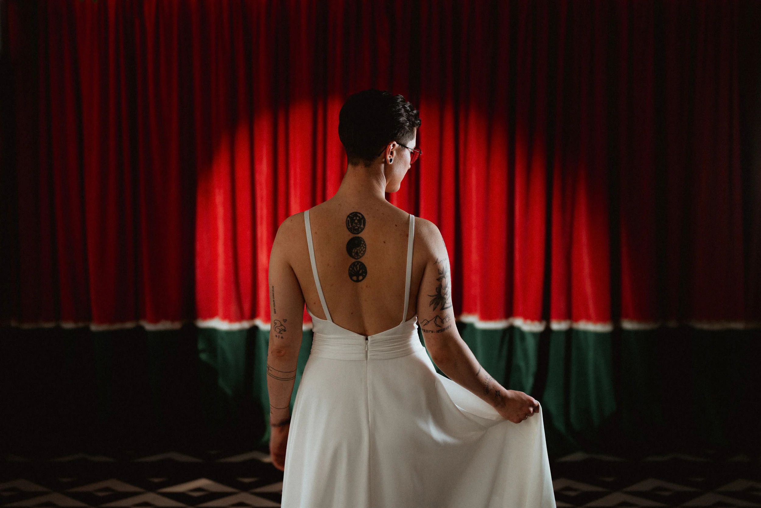 Wedding portrait of a bride in front of red curtains with dramatic light