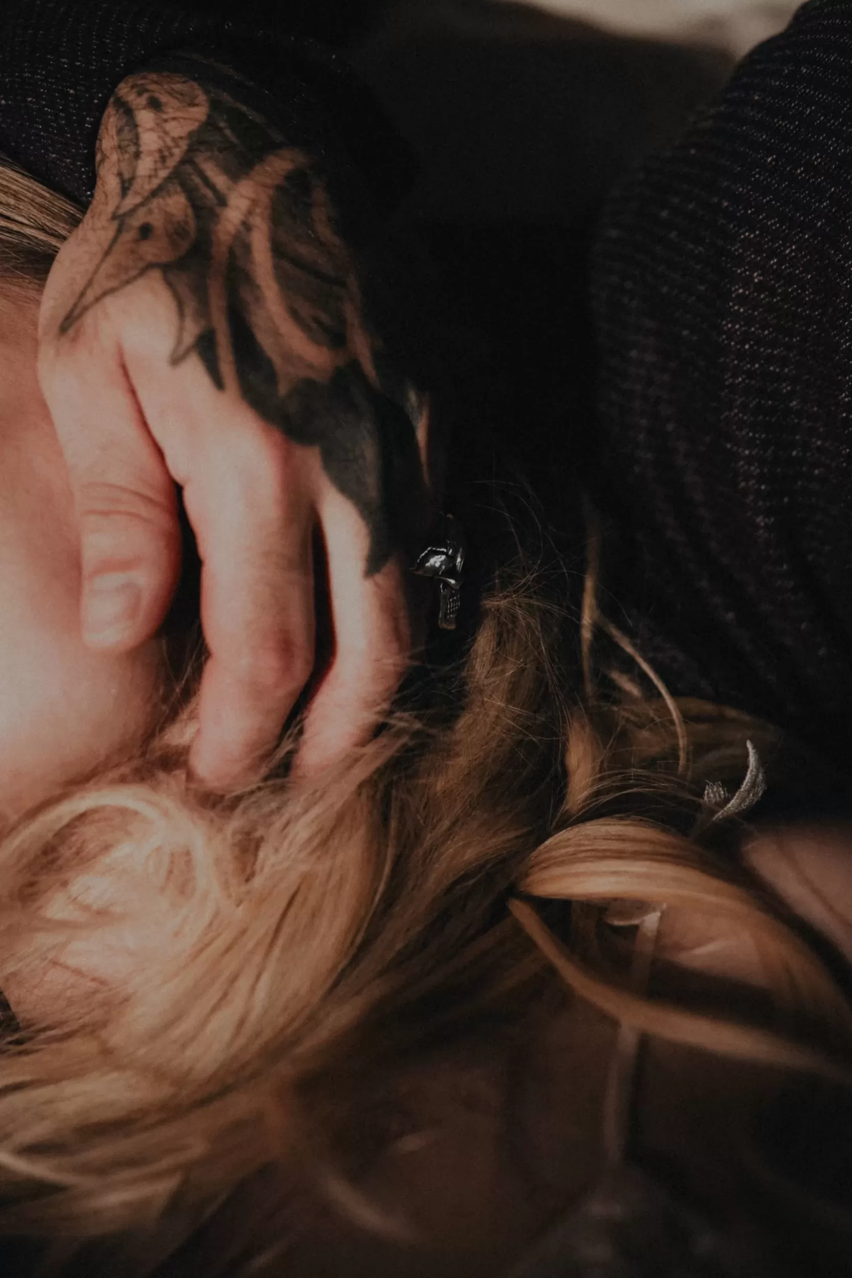 closeup wedding photo of a grooms hand on the bride with warm dramatic light