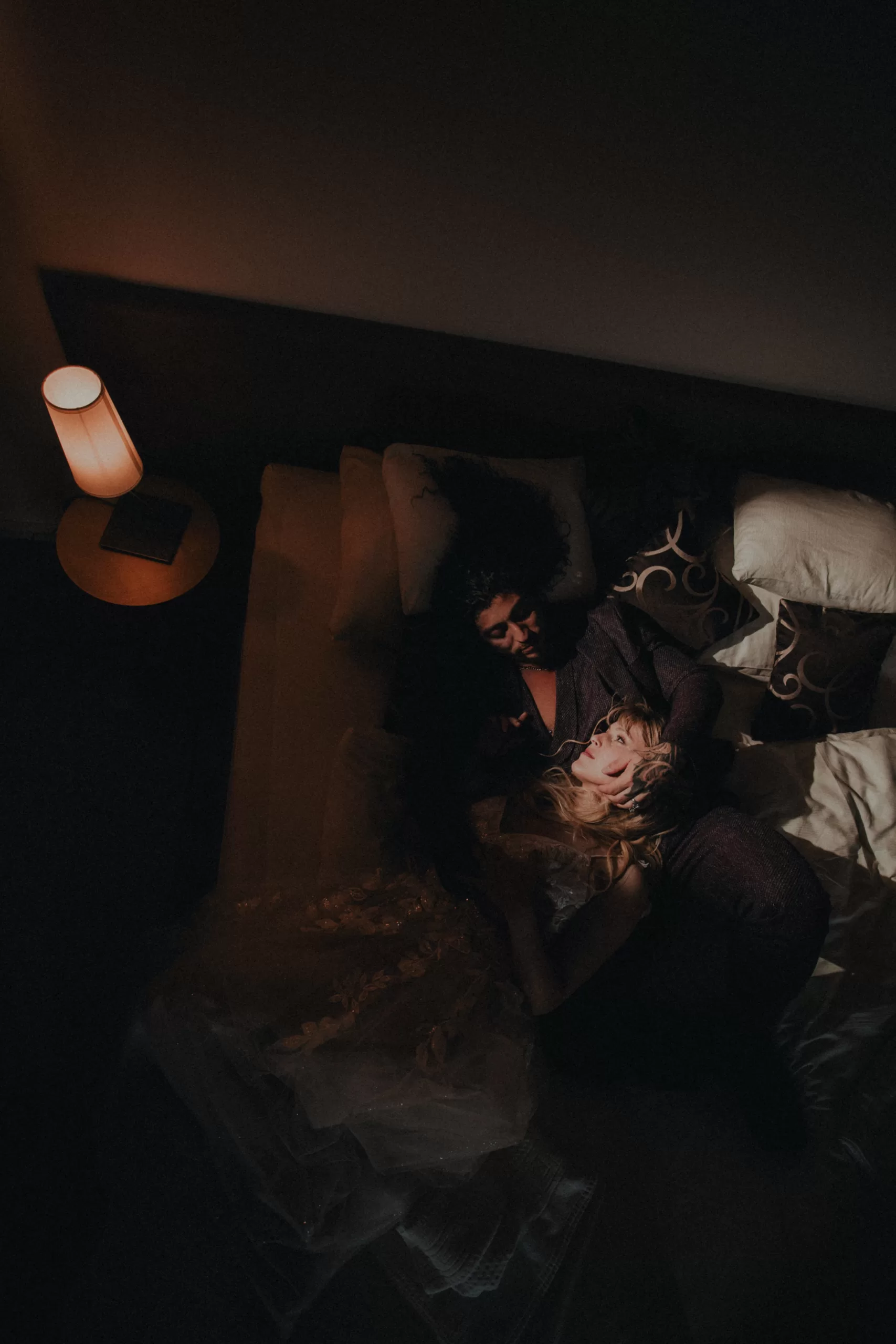 A wedding couple in a hotel on a bed with dramatic light