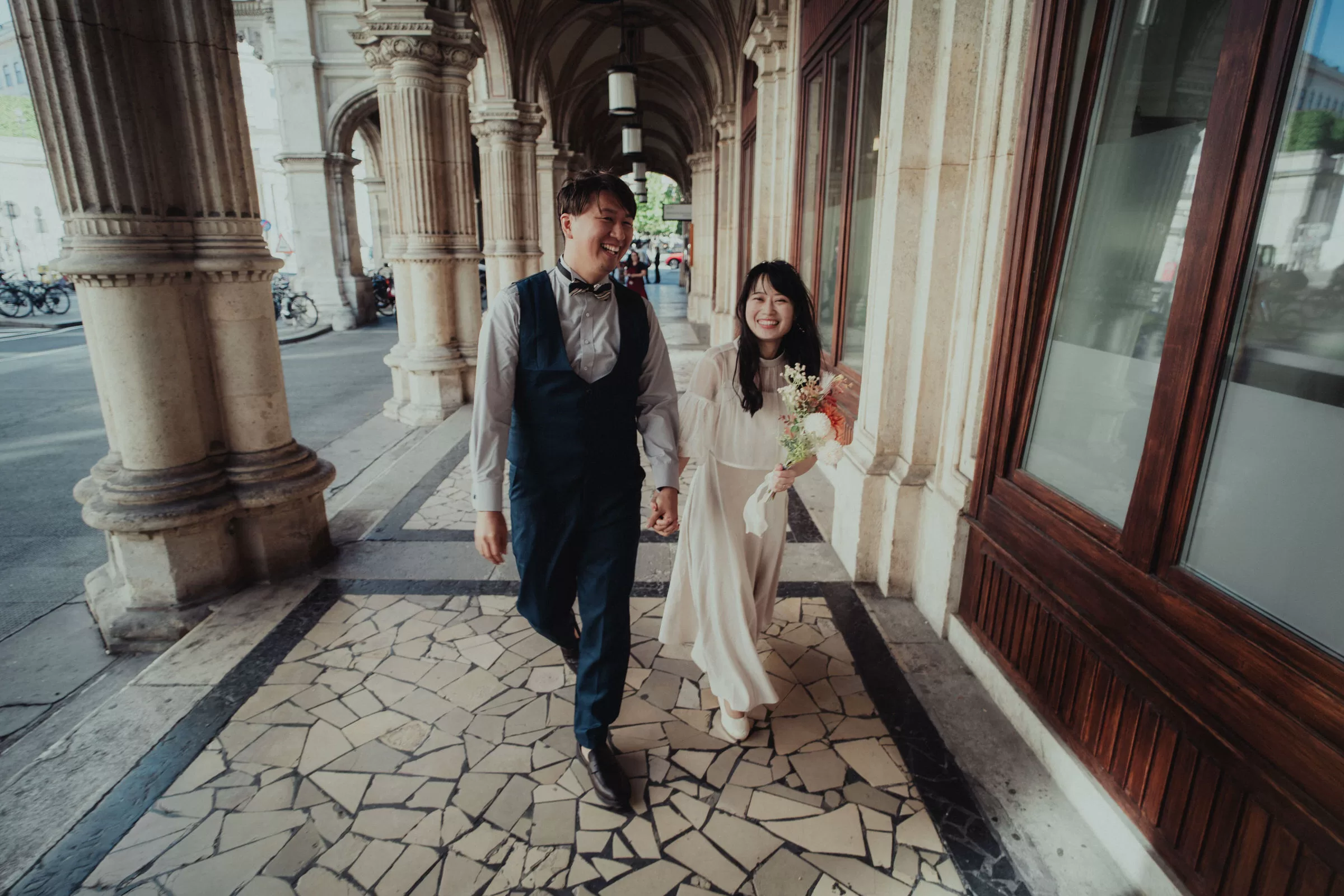 Couple photo in Vienna city centre: a couple walking through a gallery of Vienna state opera