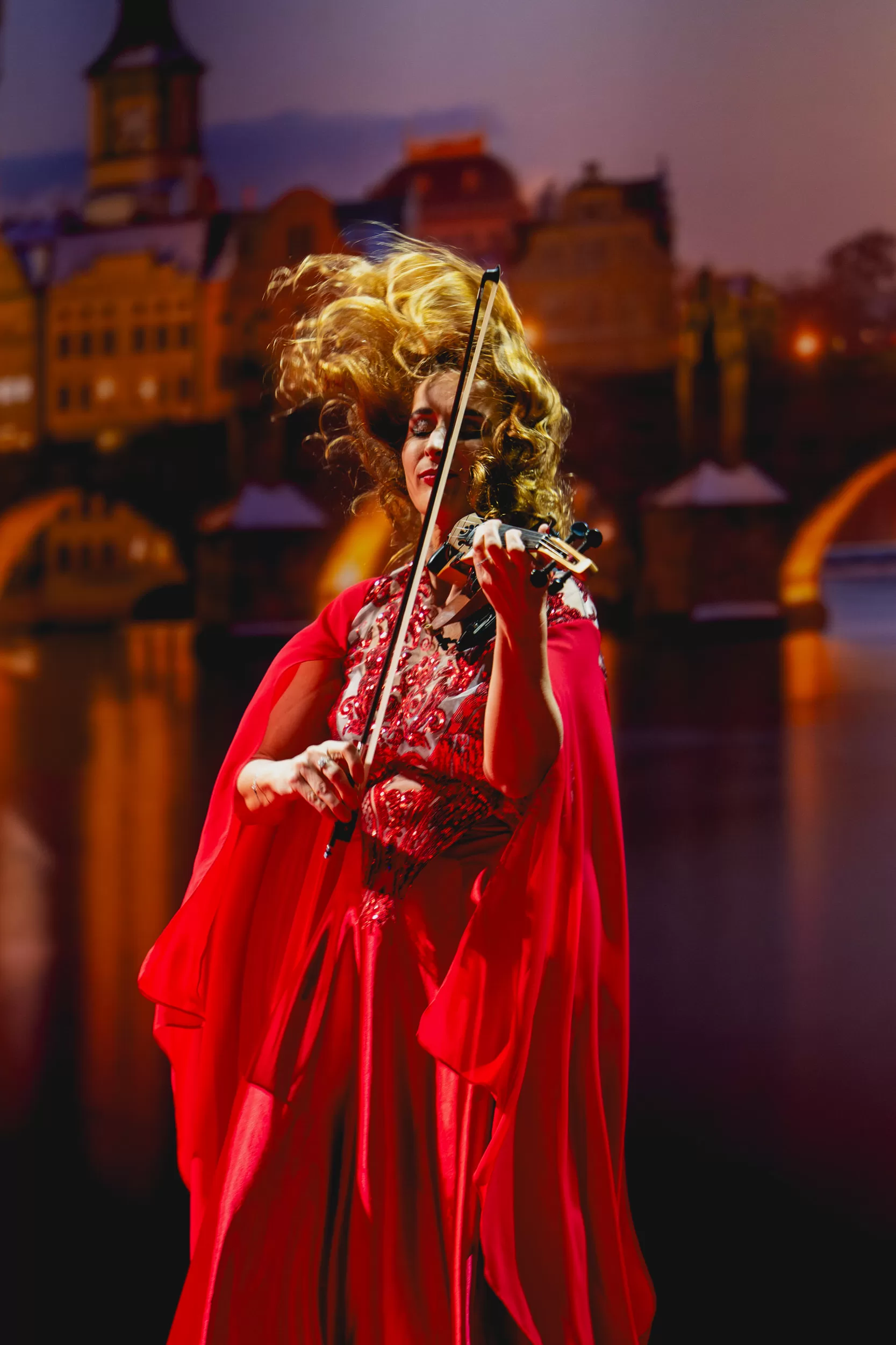 A woman with a musical instrument in front of an old city background