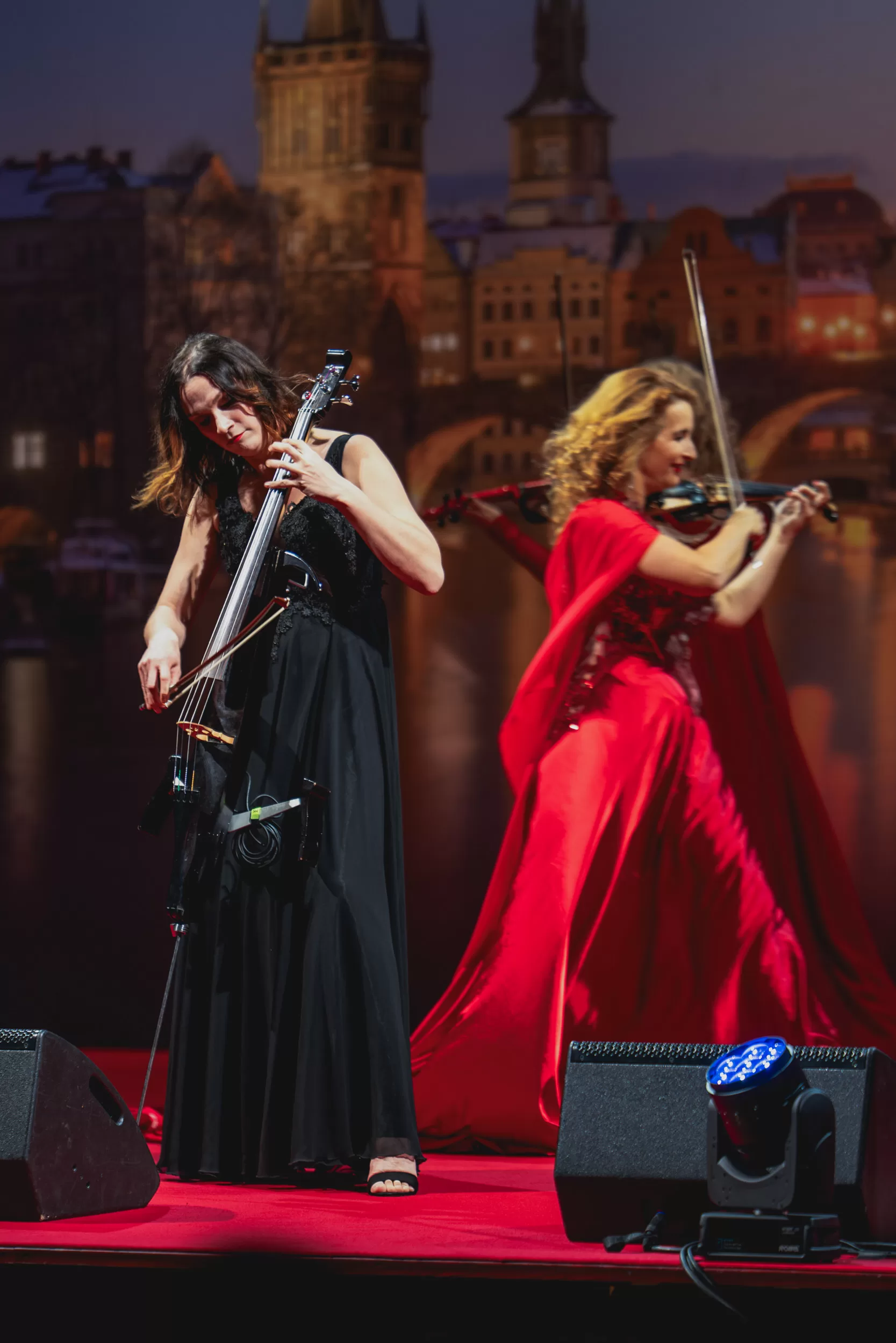 2 musicians on stage with a background of the old city of Prague