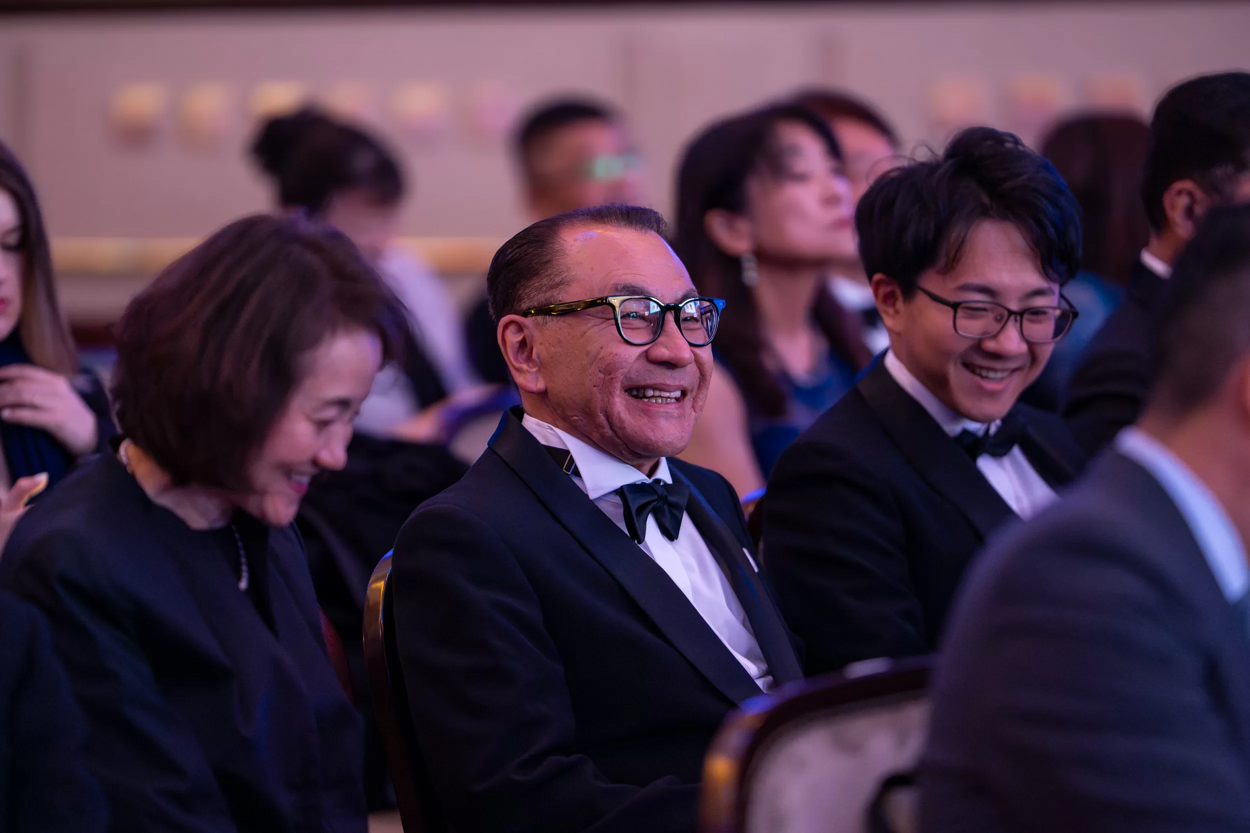 Participants of an award ceremony smiling and sitting in the hall