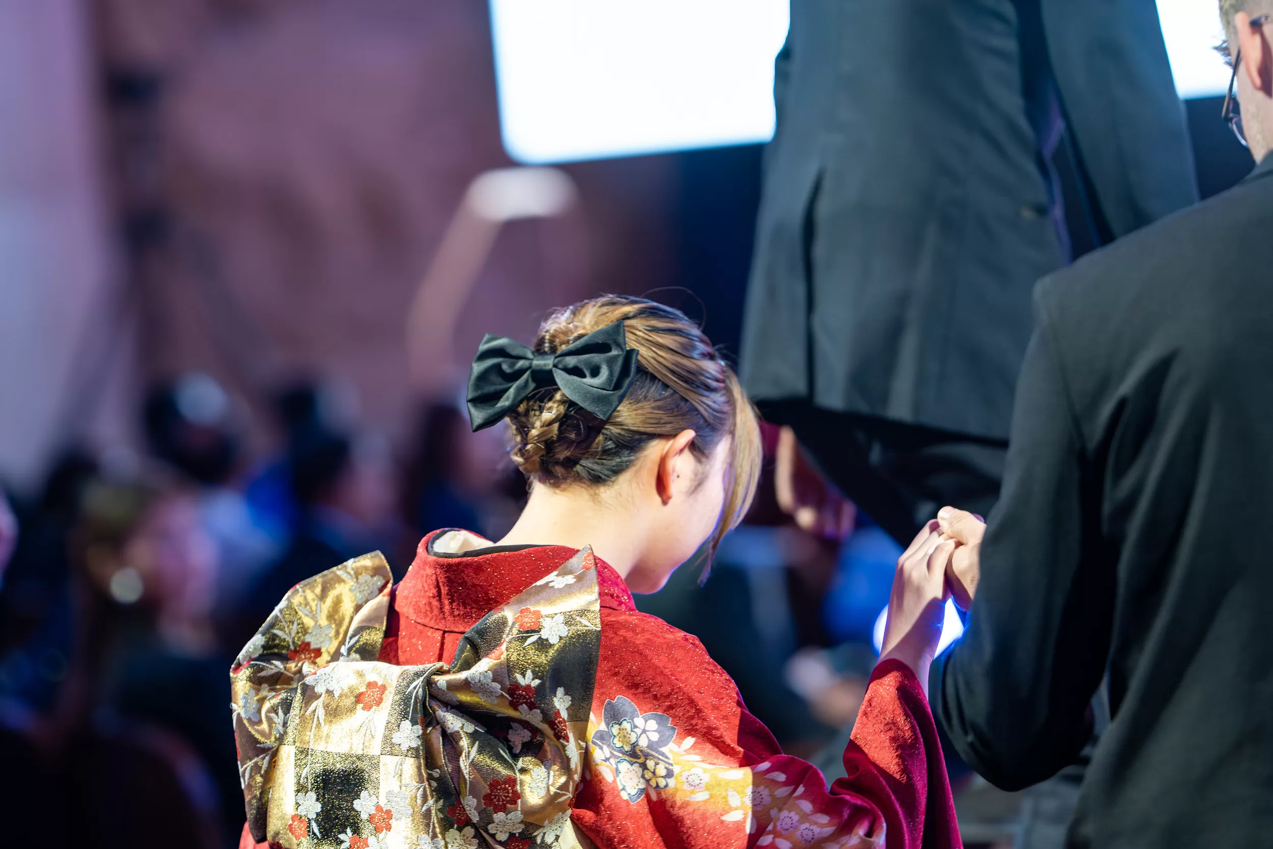 A woman in traditional clothing going up to the stage