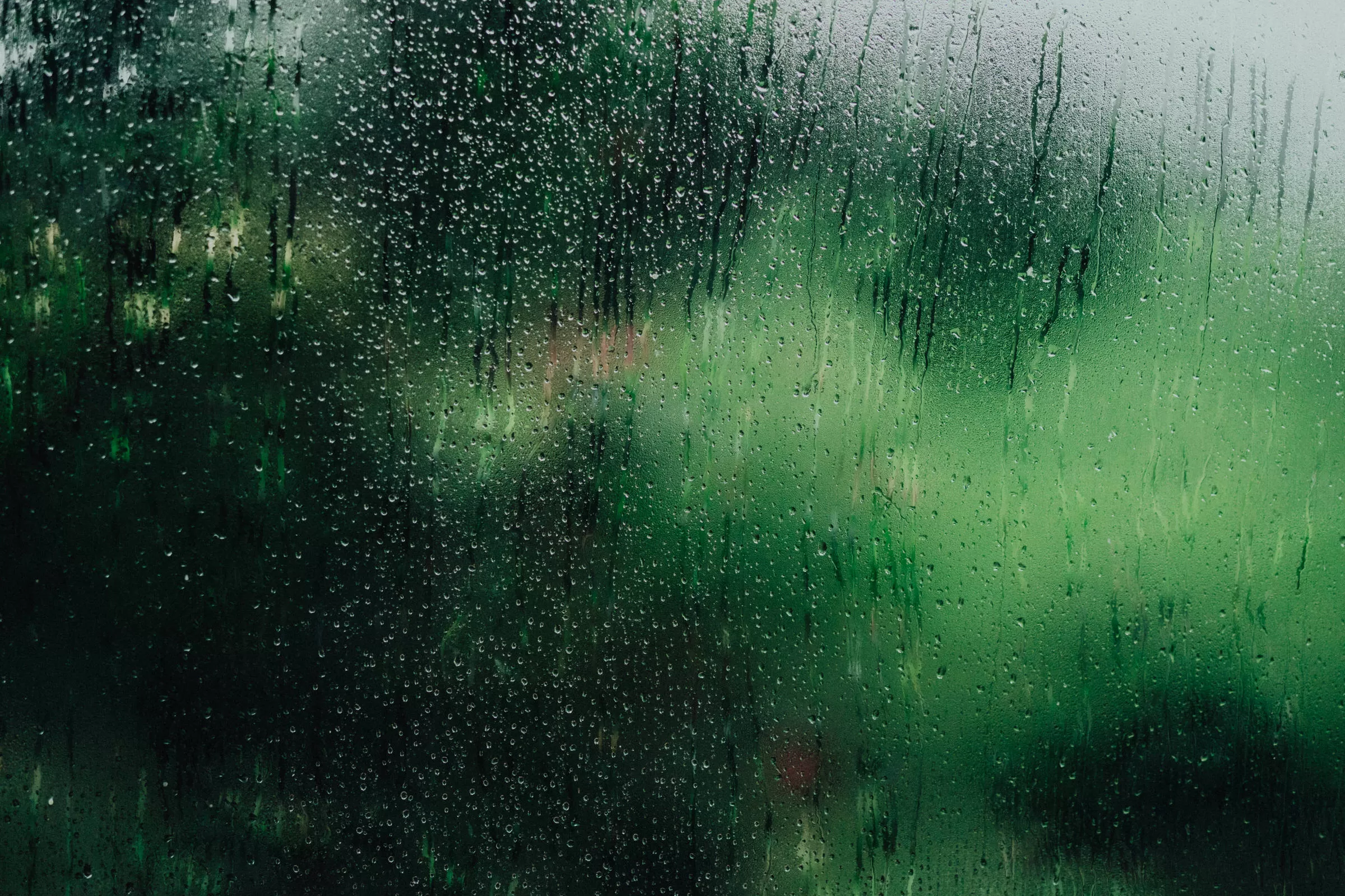Background for Viennese wine region wedding photos gallery. wet window with raindrops and a view on green hills