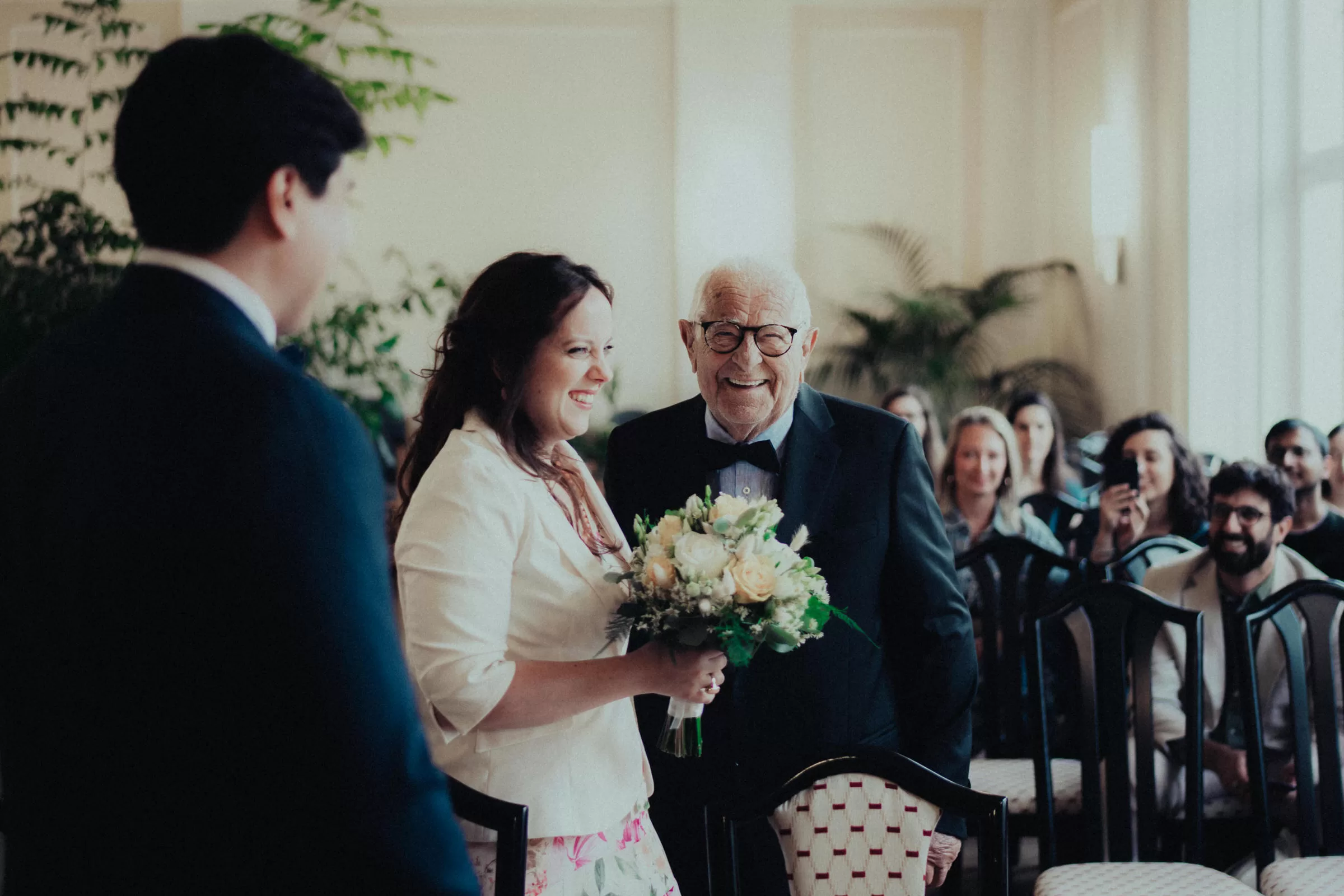 Groom and bride with guests in the ceremony hall before the start of the ceremony