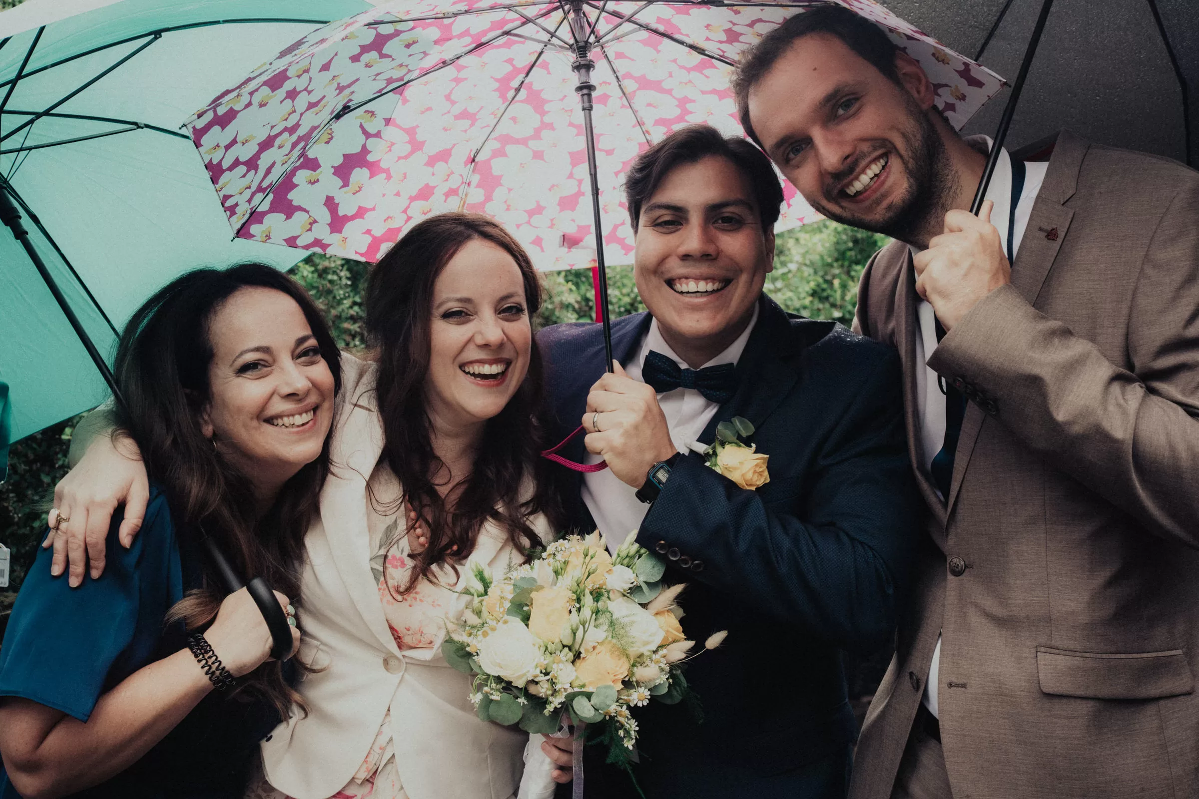newlyweds with their family members under umbrellas on their wedding day photo by a wedding photographer fedor vasilev