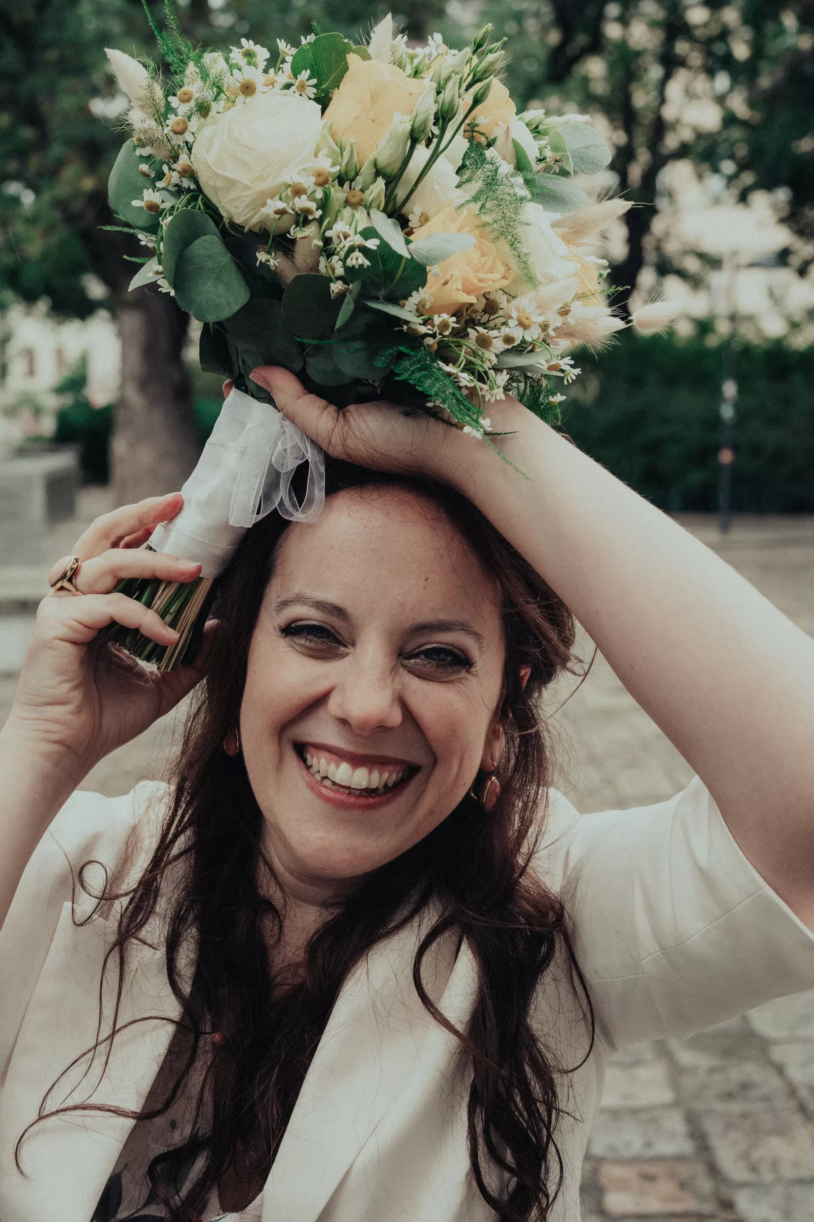 a bride with a bouquet trying to hide from the rain