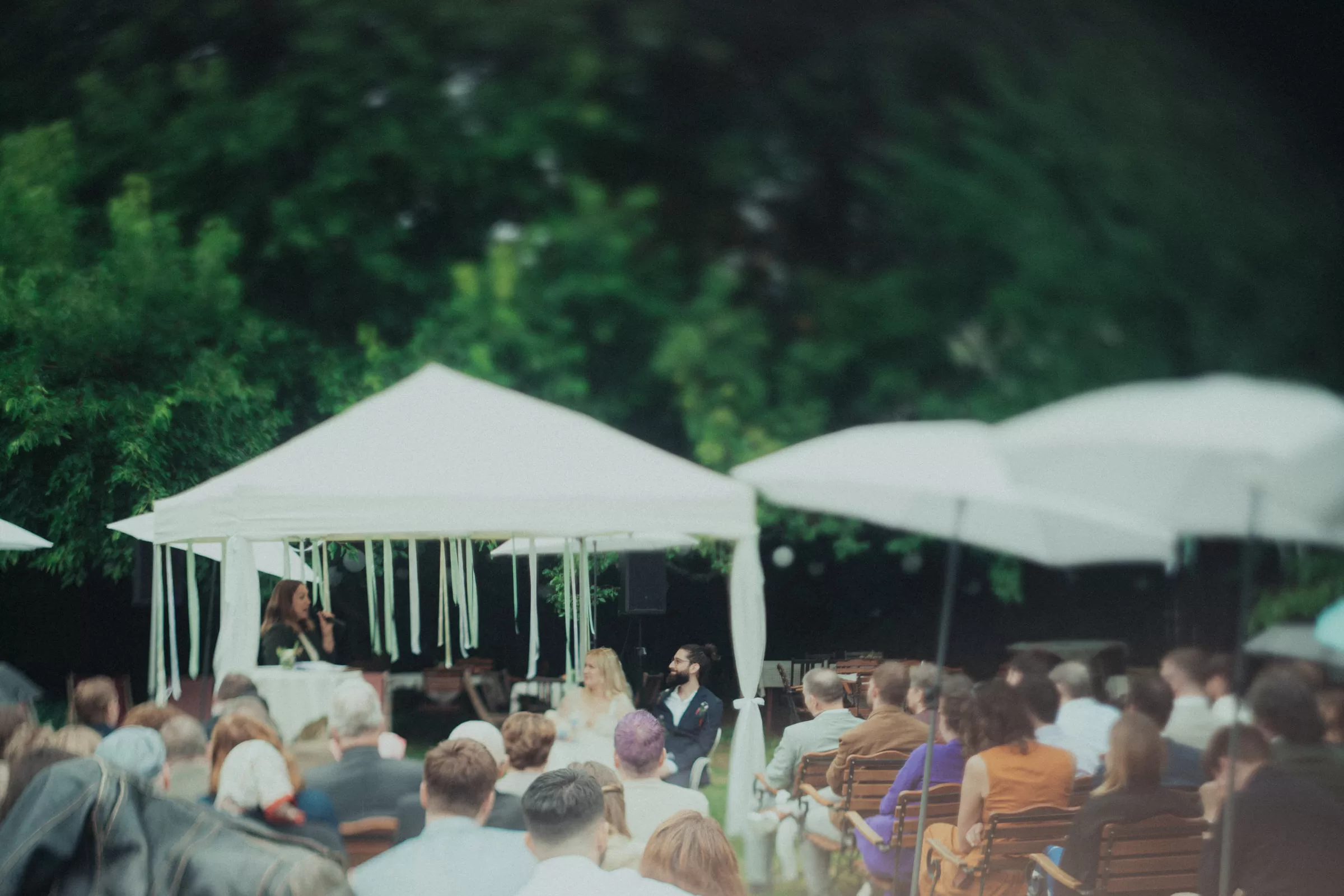 Atmosphere photo of a wedding ceremony in a garden on a rainy day
