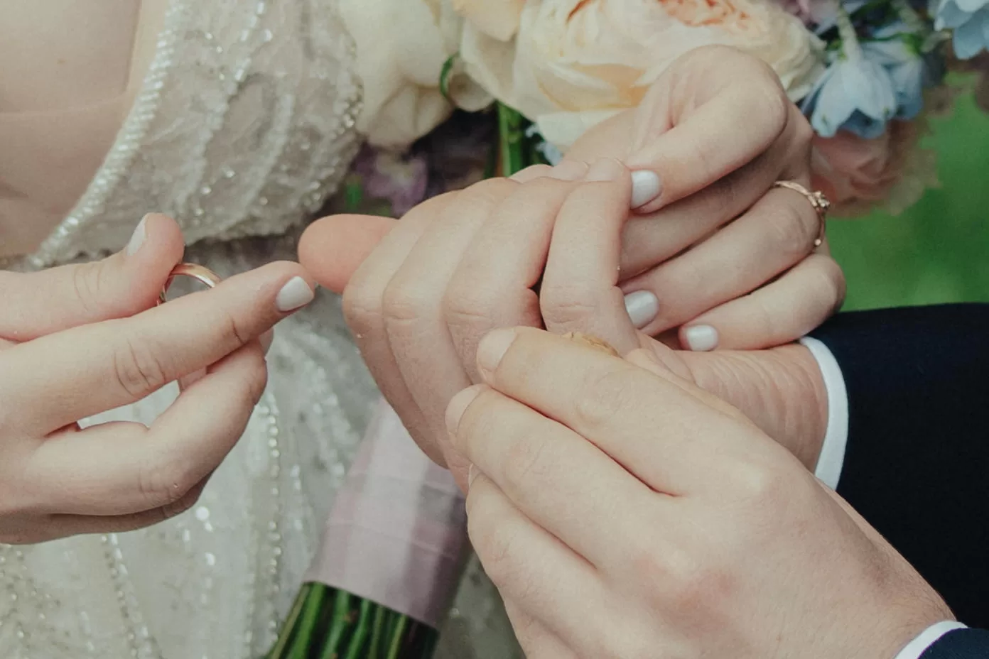 A couseup of hands of a couple exchanging rings