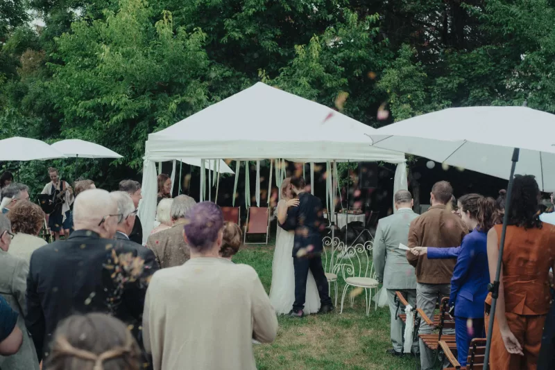Vienna garden wedding photos, a couple kissing during their ceremony in a garden of a heuriger