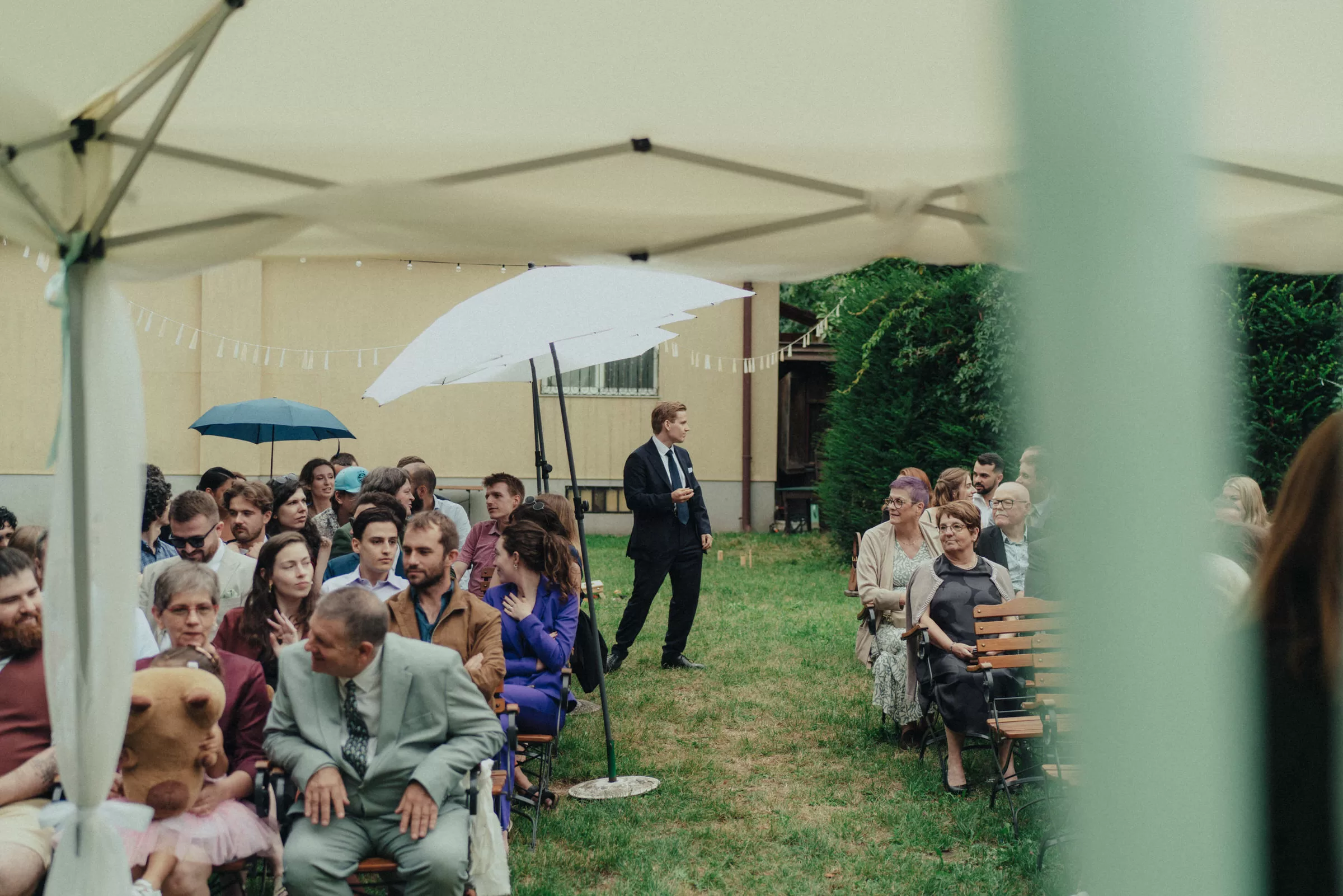 wedding guests waiting for the couple to arrive in a garden on a ceremony