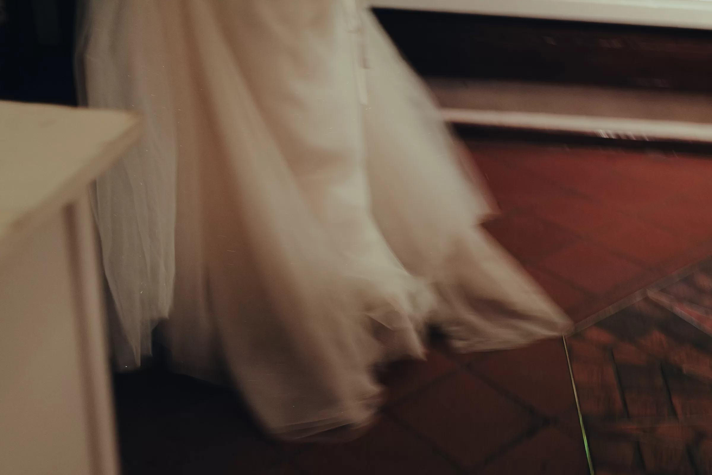 Abstract blurred photo of a bride walking in a wedding dress with warm light in a wedding venue