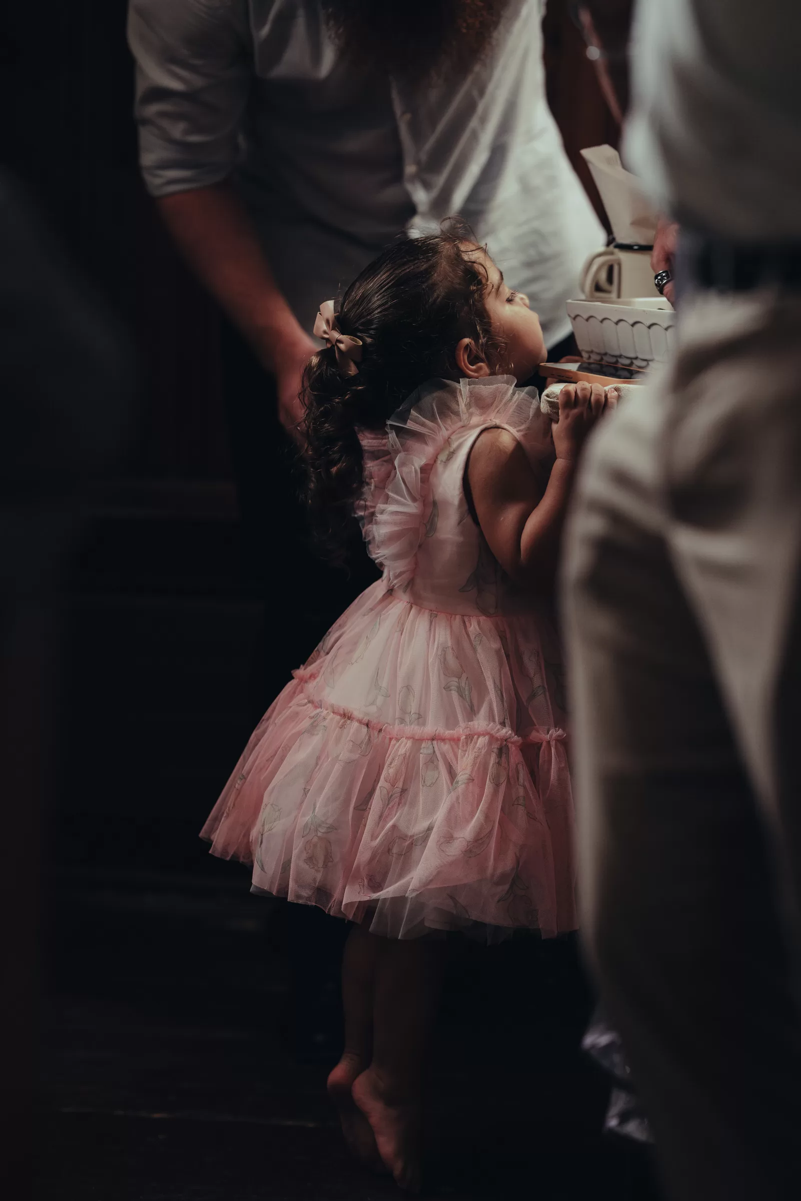 A child next to a table in a dress on a wedding