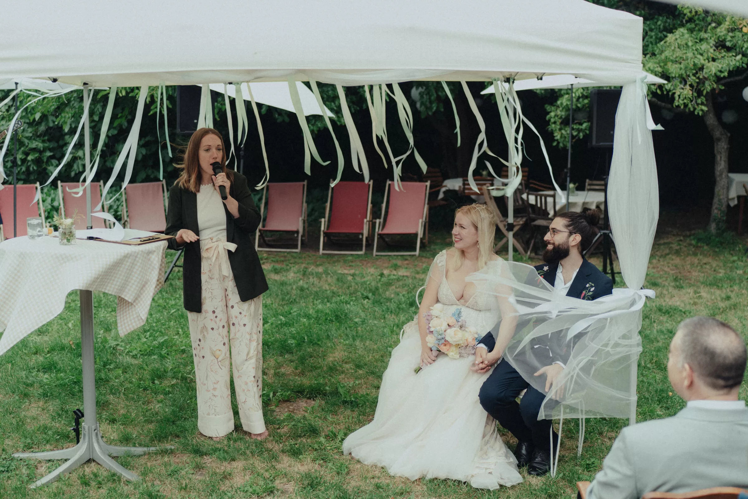 couple sitting on their ceremony in a garden of a viennese winery on a windy day
