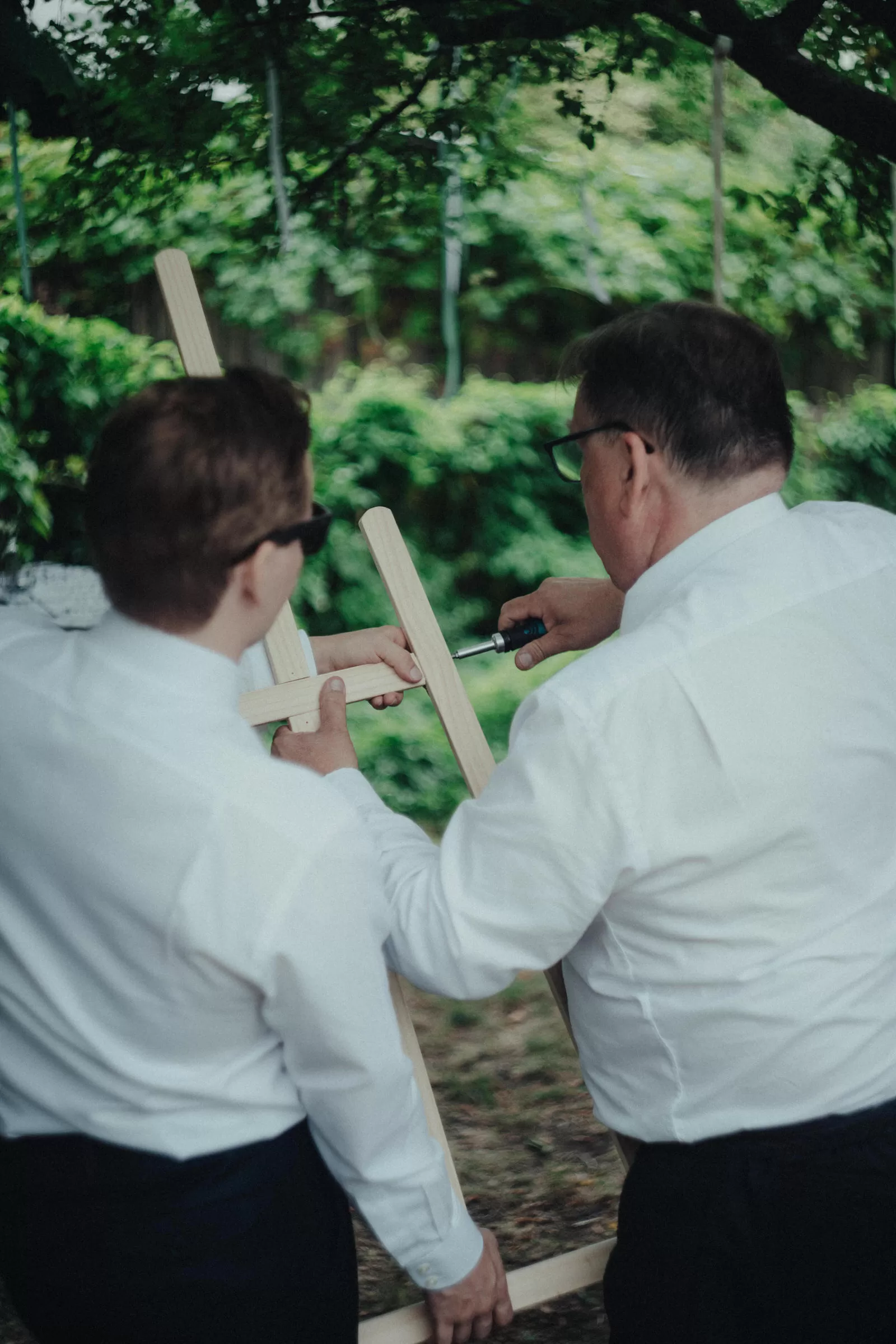 Men assembling easel for a wedding in a garden