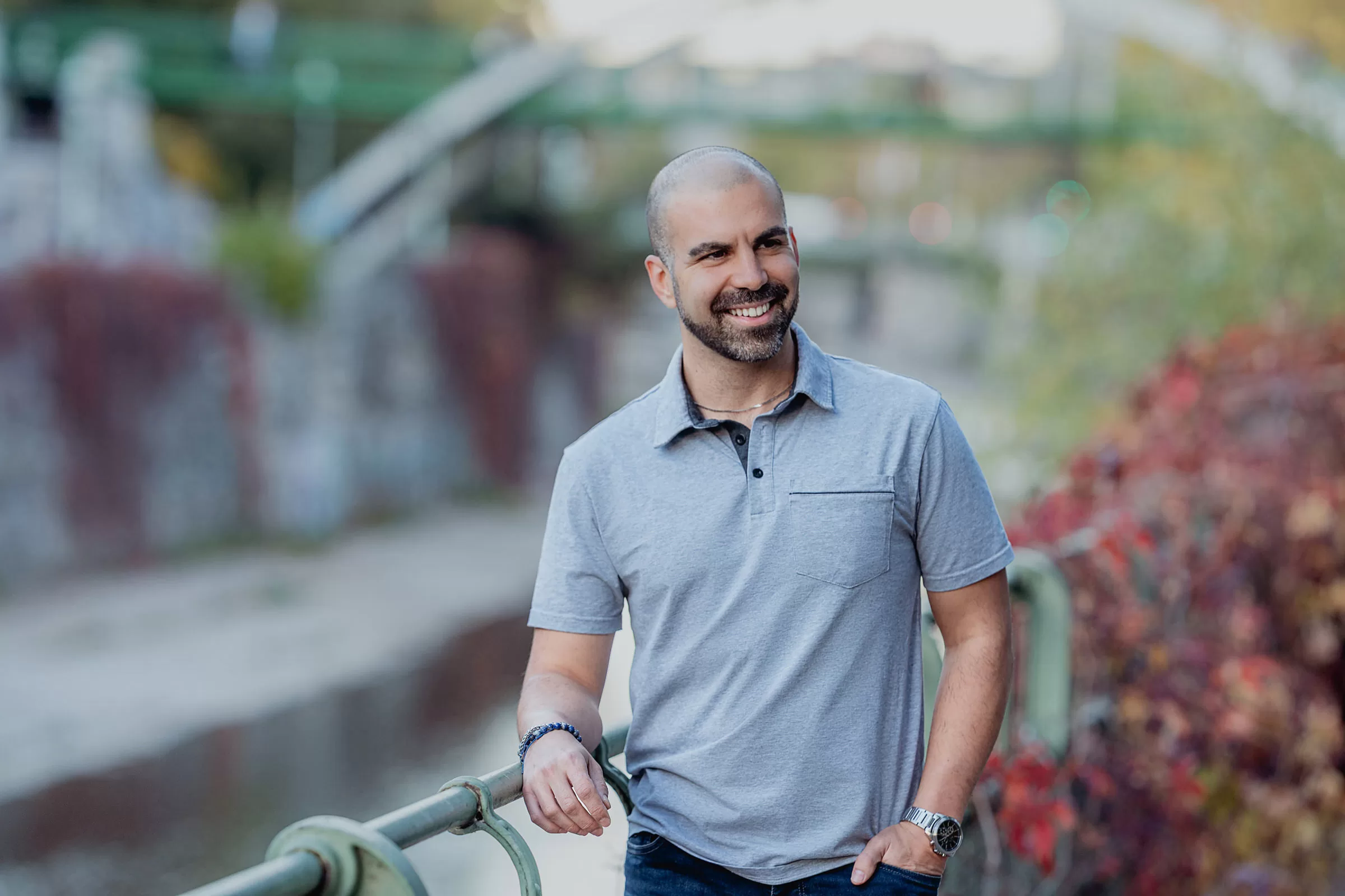 Autumn portrait of a man in Stadtpark in Vienna with bridges in the background