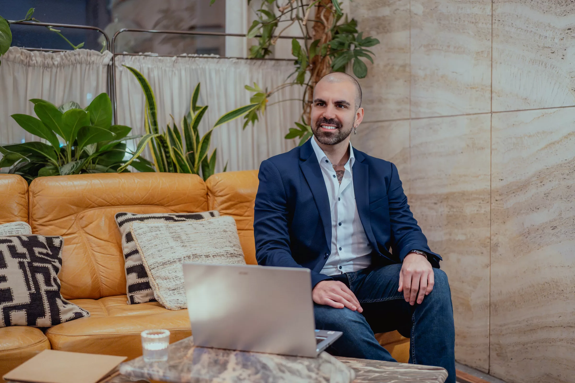 Portrait of a man in a classic suit sitting on a couch in front of laptop by Fedor Vasilev