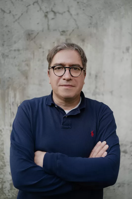Corporate Photography in Berlin Fedor Vasilev Photographer In Berlin Corporate headshot with natural light; A man in blue sweater in front of grey concrete textured background