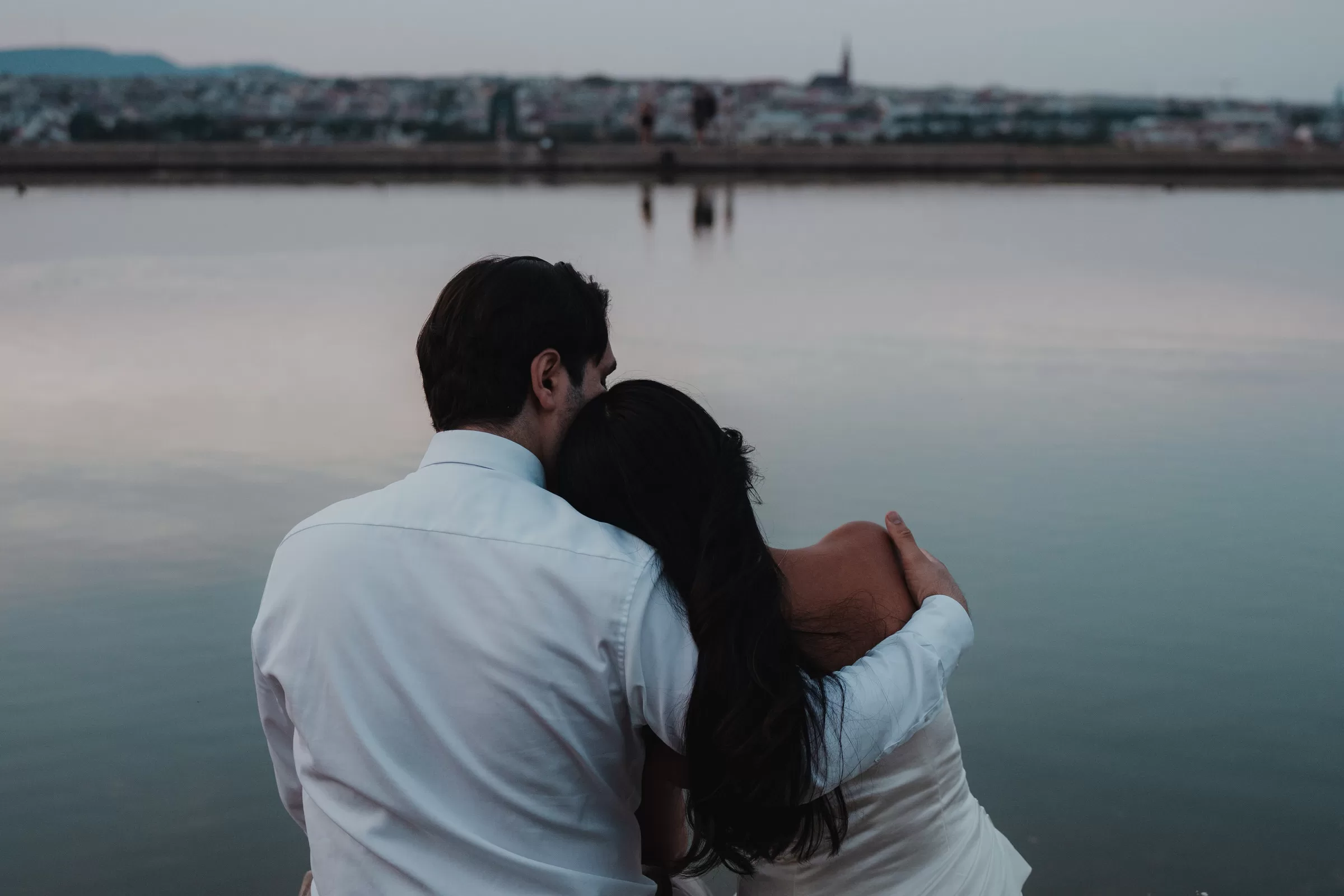 Couple sitting by a pond at schoenbrunn in Vienna 