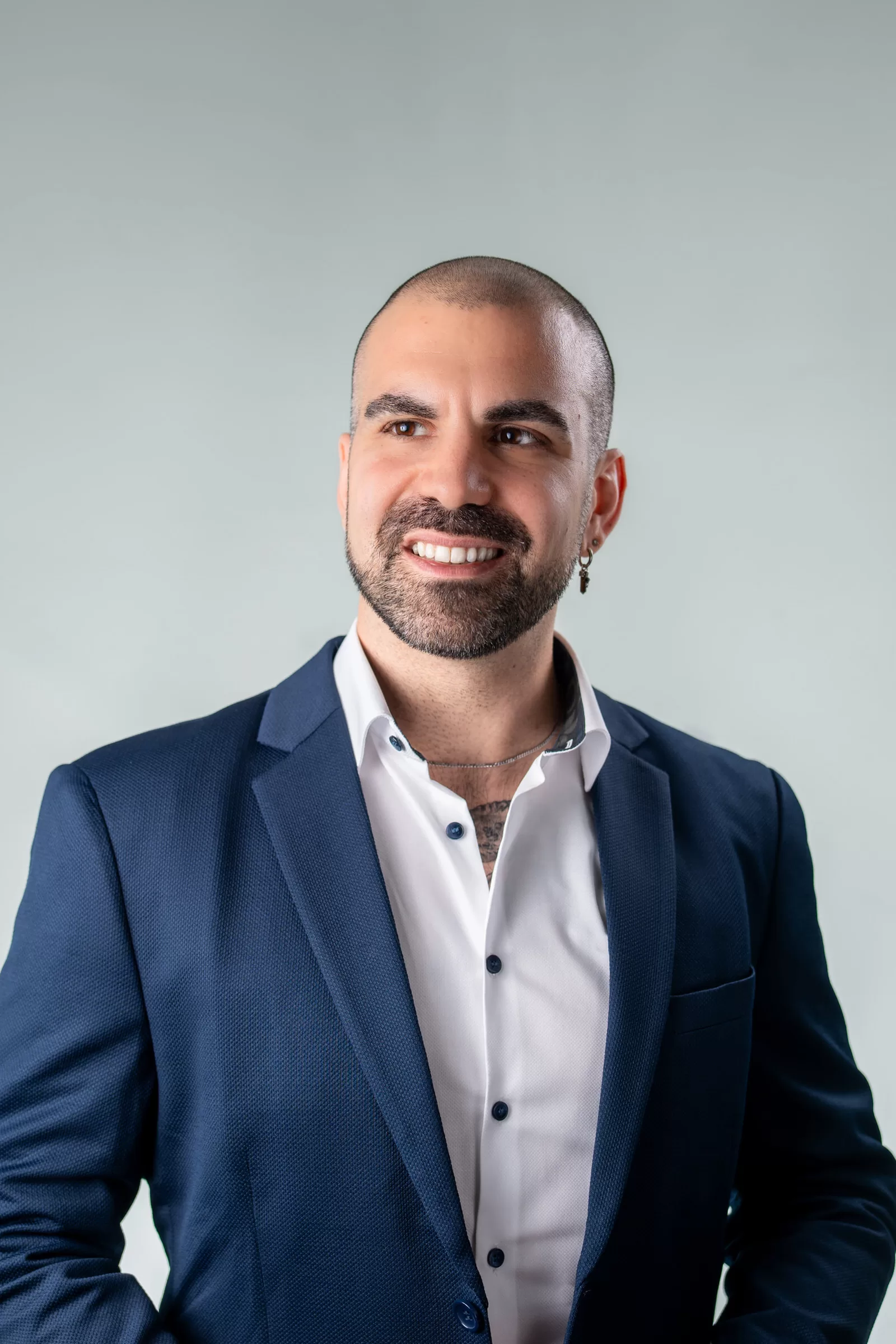 Modern and a bit dramatic headshot portrait of a businessman in Vienna in front of a grey background