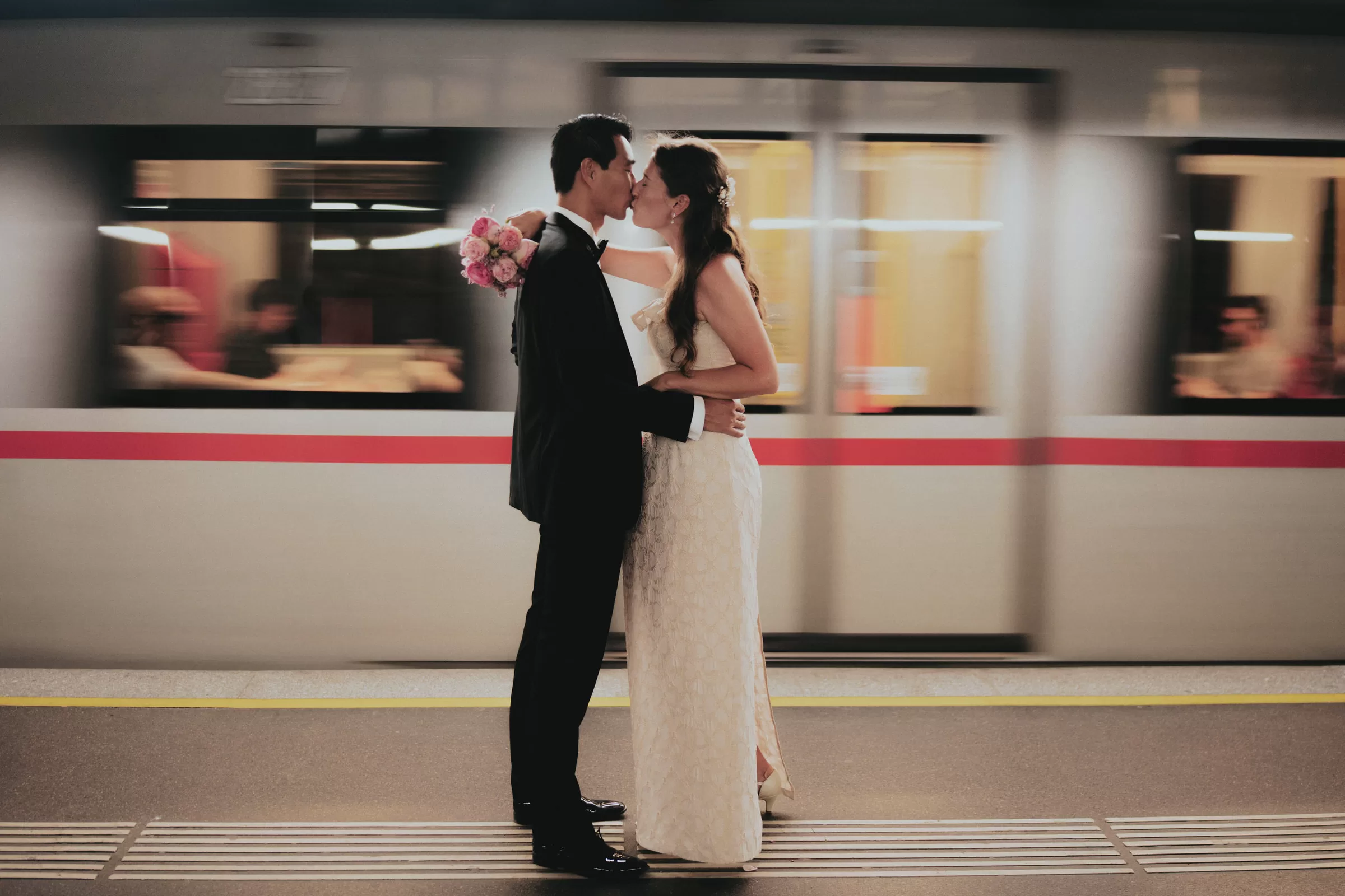 A couple kissing in viennese U-Bahn with a passing train in the background