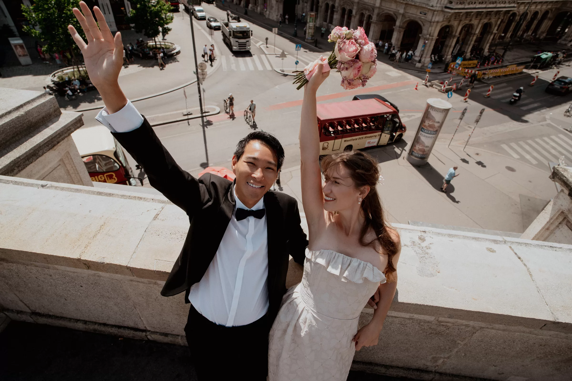 A couple in Vienna on a terrace with a view over a city square