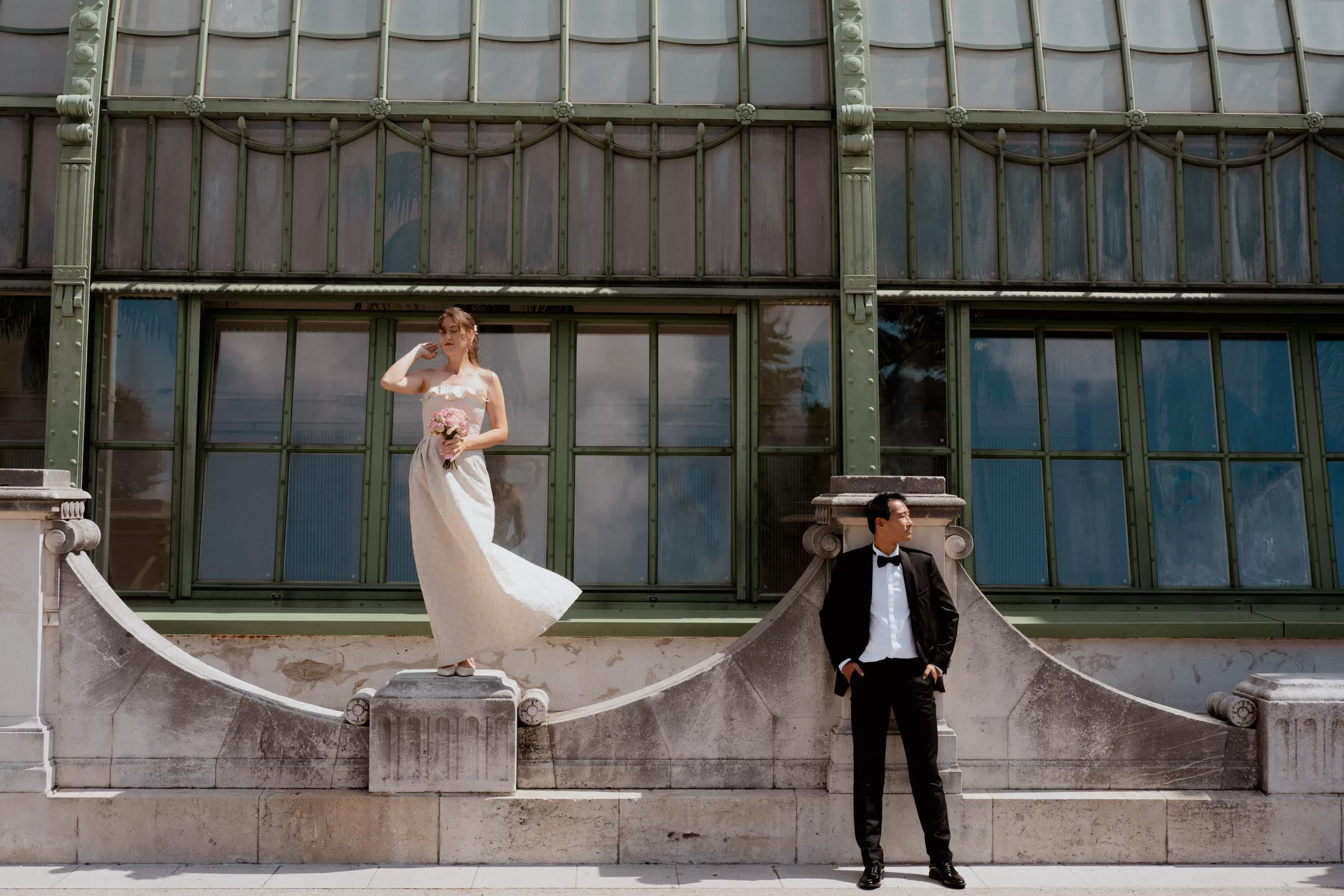 A couple photo of a groom and a bride standing next to the Green house in Burggarten in Vienna