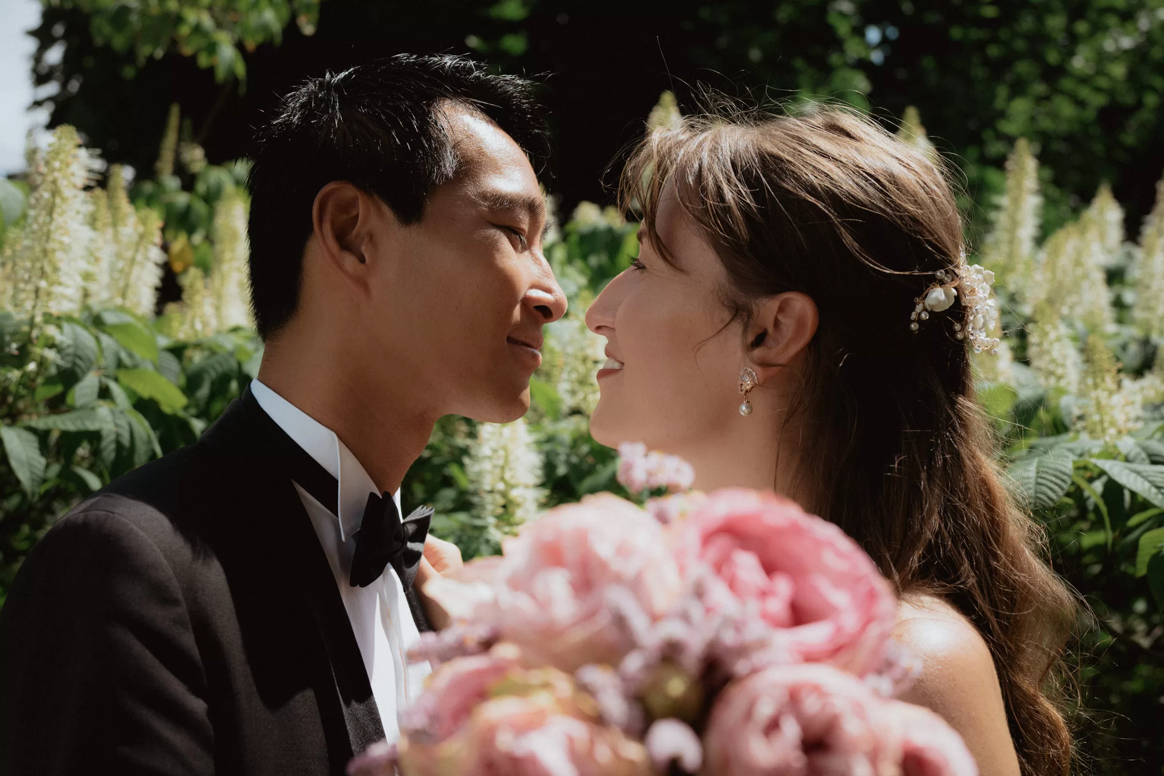 Couple photo of a man and a woman in engagement outfits in a park in Vienna with a bouquet of flowers