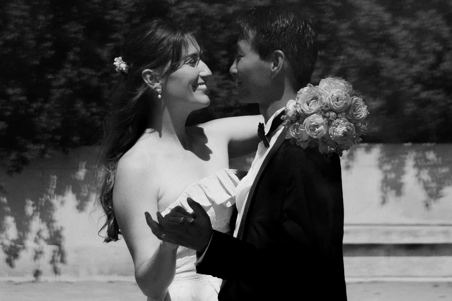 Black and white photo of a couple hugging and dancing in a corner of Volksgarten next to Kaiserin-Elisabeth-Denkmal
