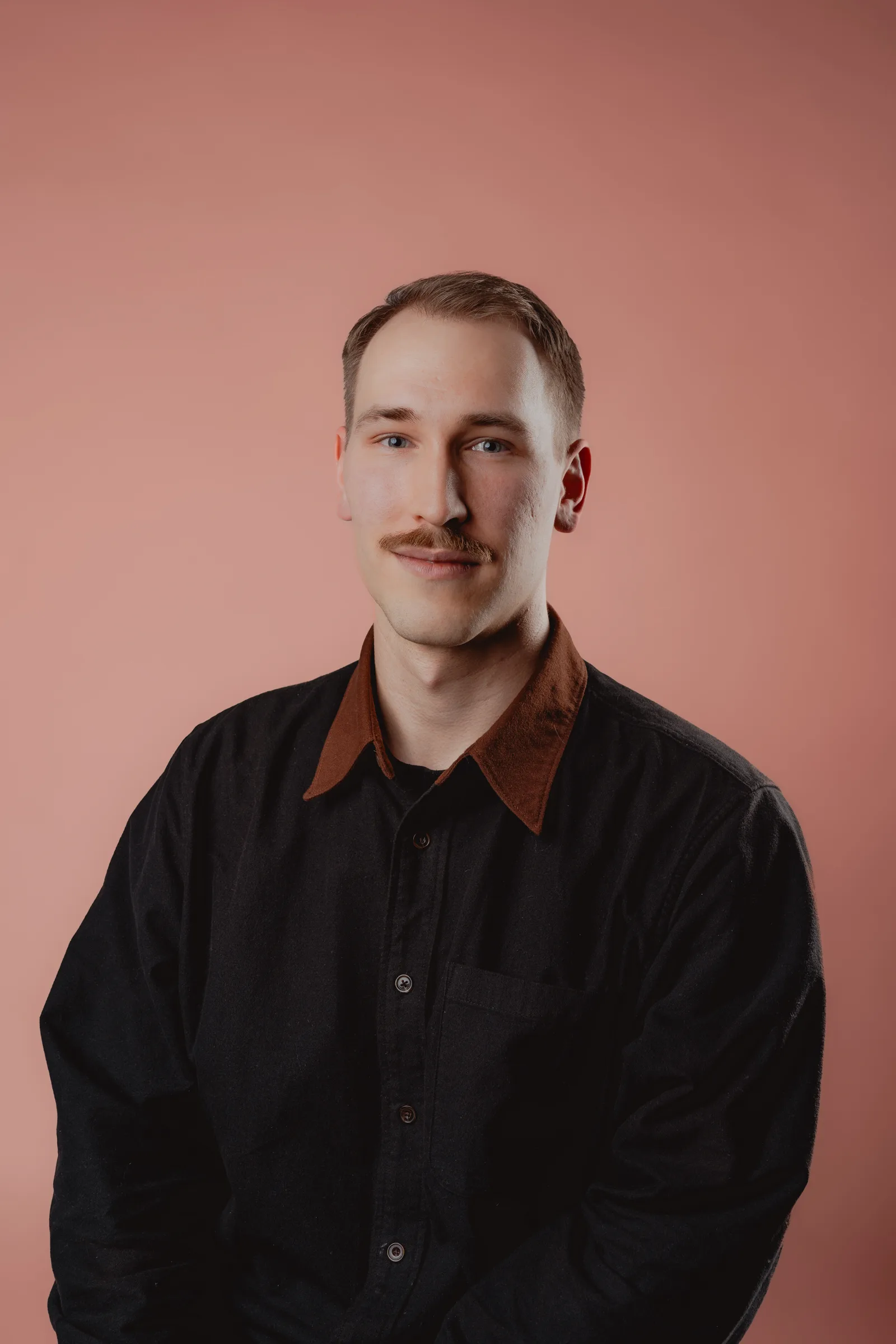 Classic male studio portrait in front of a coloured background, in Vienna