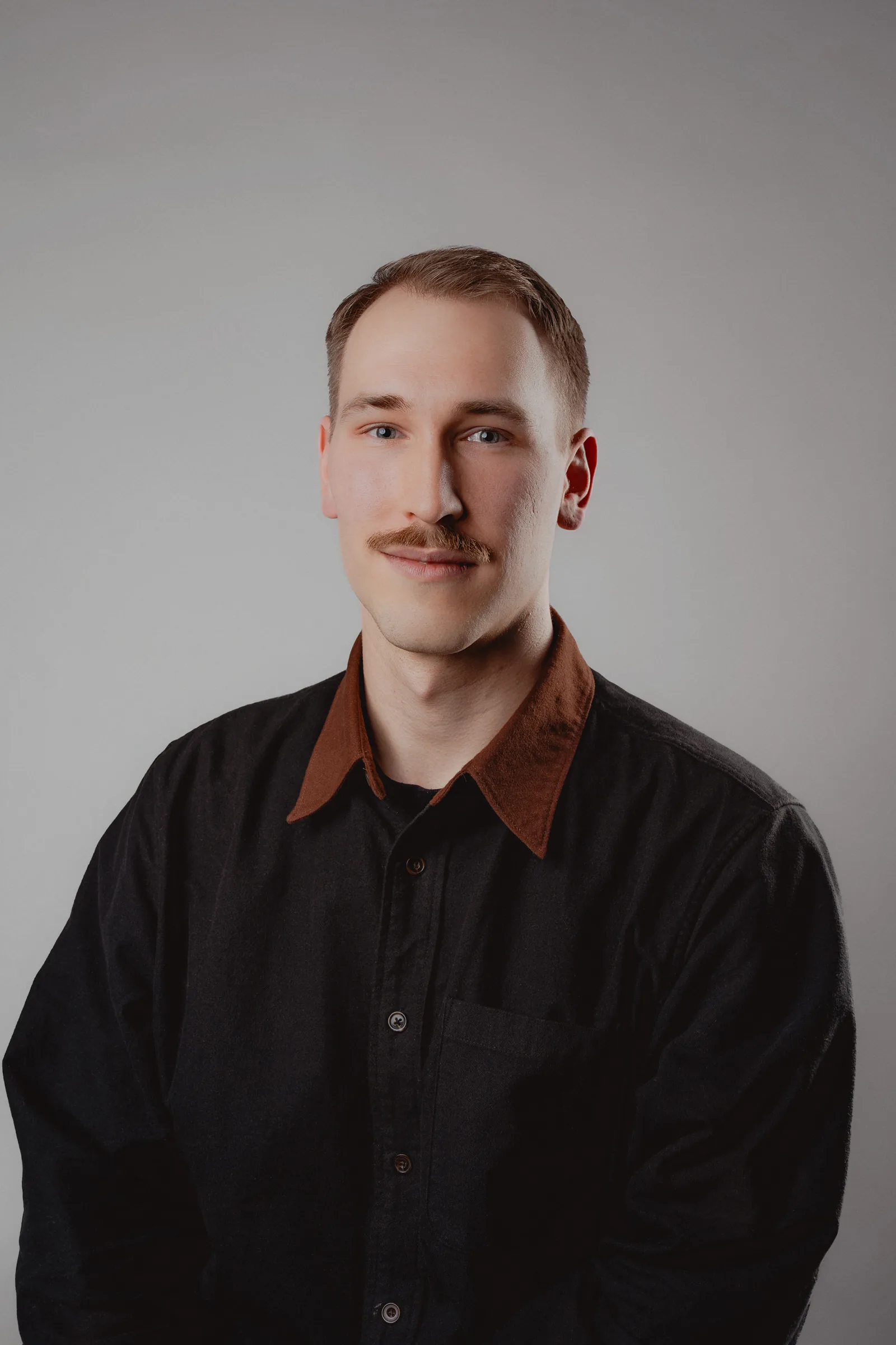 Simple, sharp headshot for company profiles, grey backdrop and balanced light.