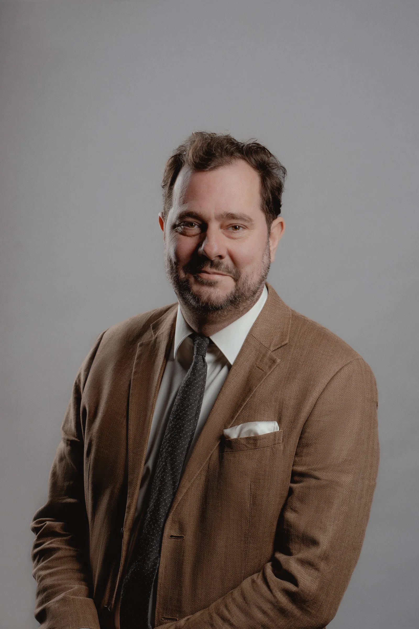 Classic Professional business portrait of a man on a grey background with clean studio lighting.