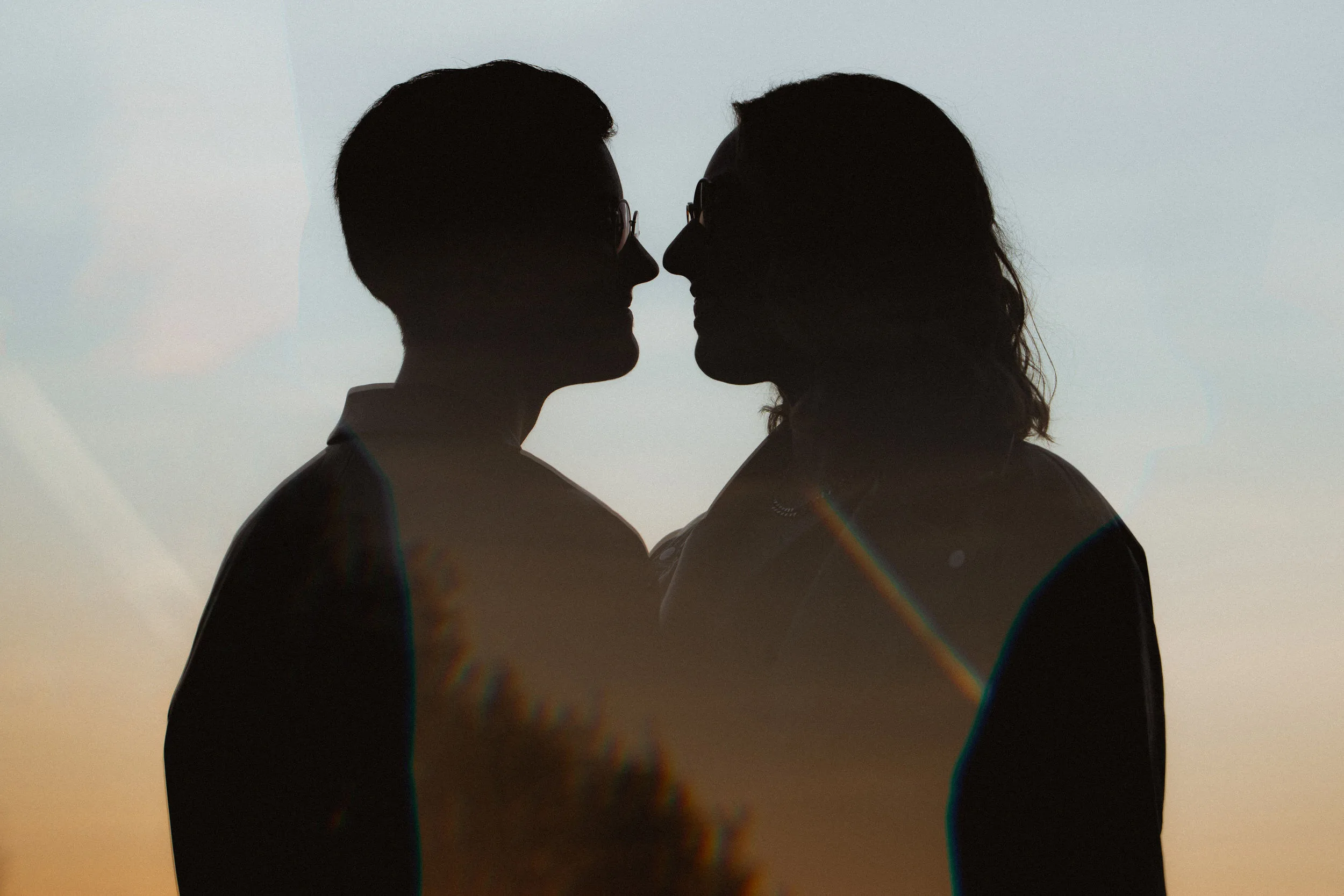 Creative double exaposure shot of a couple with sunset on the background