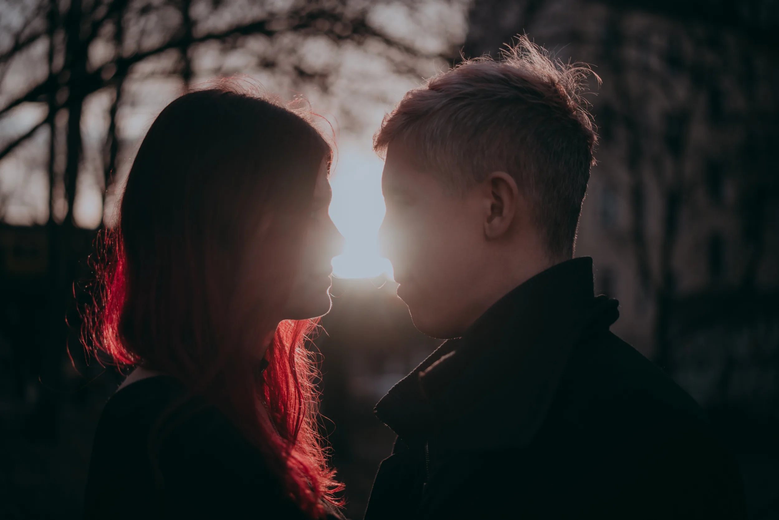 Couple hugging and looking at each other with the sun shininch between them next to Schlesisches Tor in Berlin