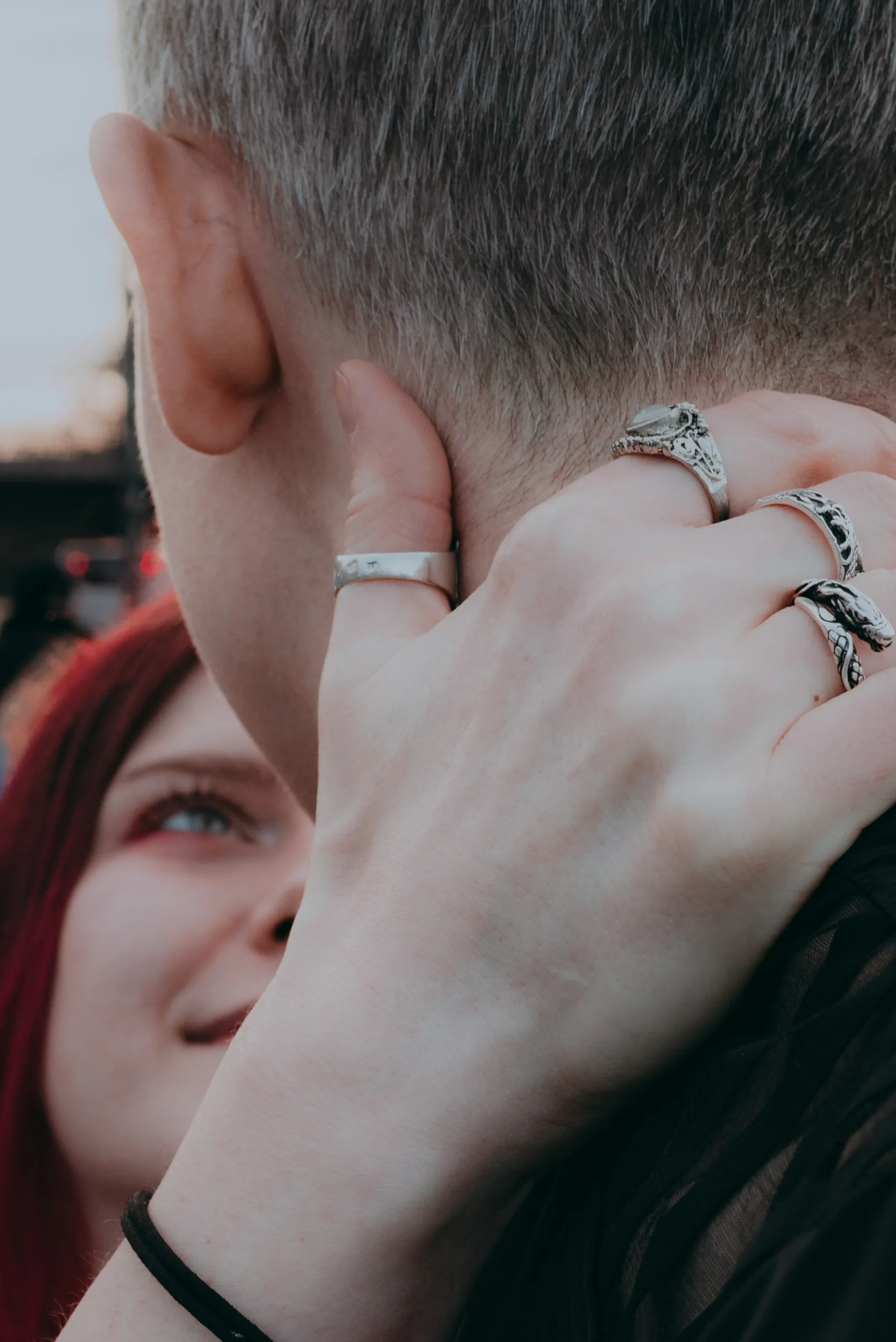 Closeup on a couple hugging and a woman holding hand around man's neck