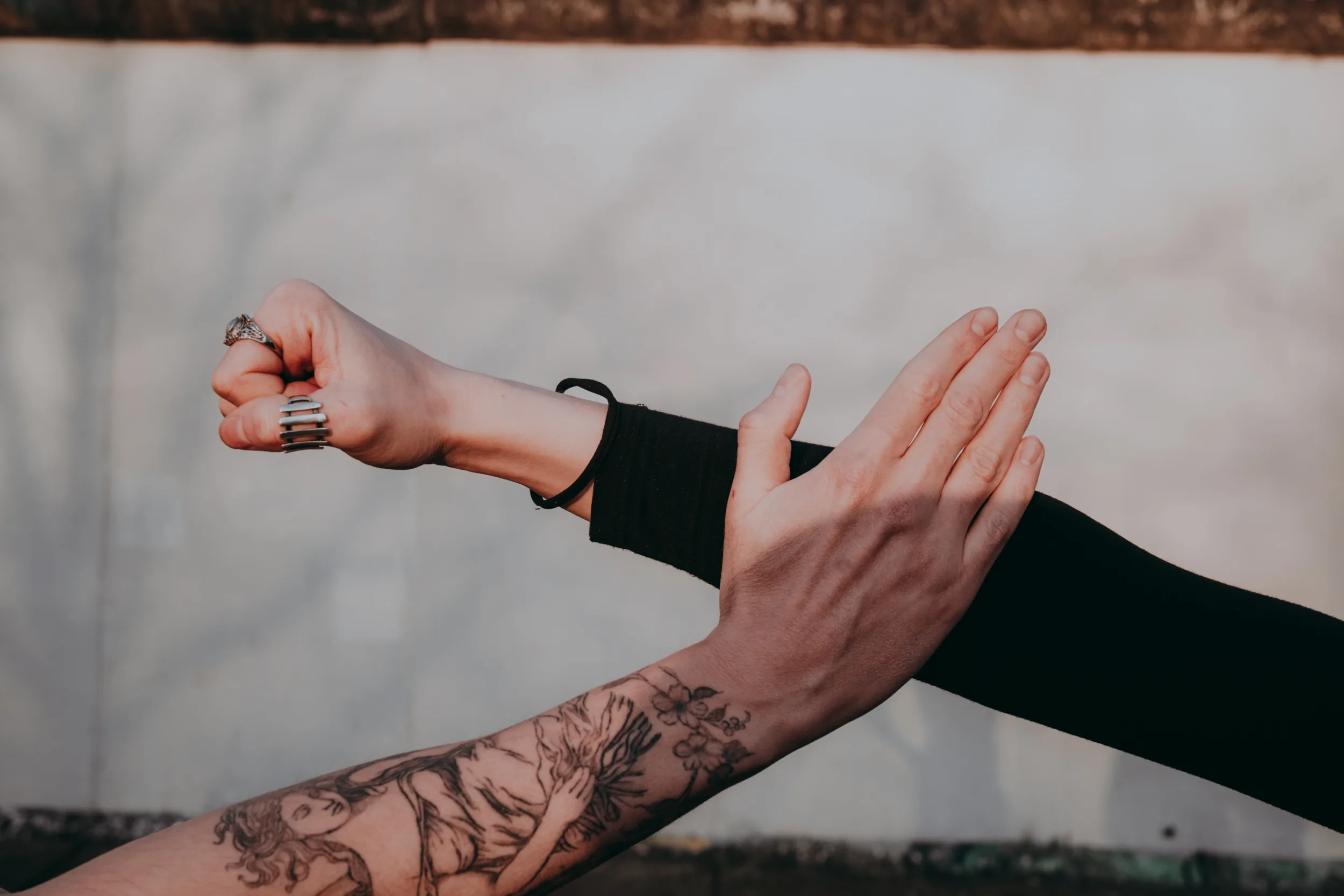 Side shot of couples hands with berlin wall on the background