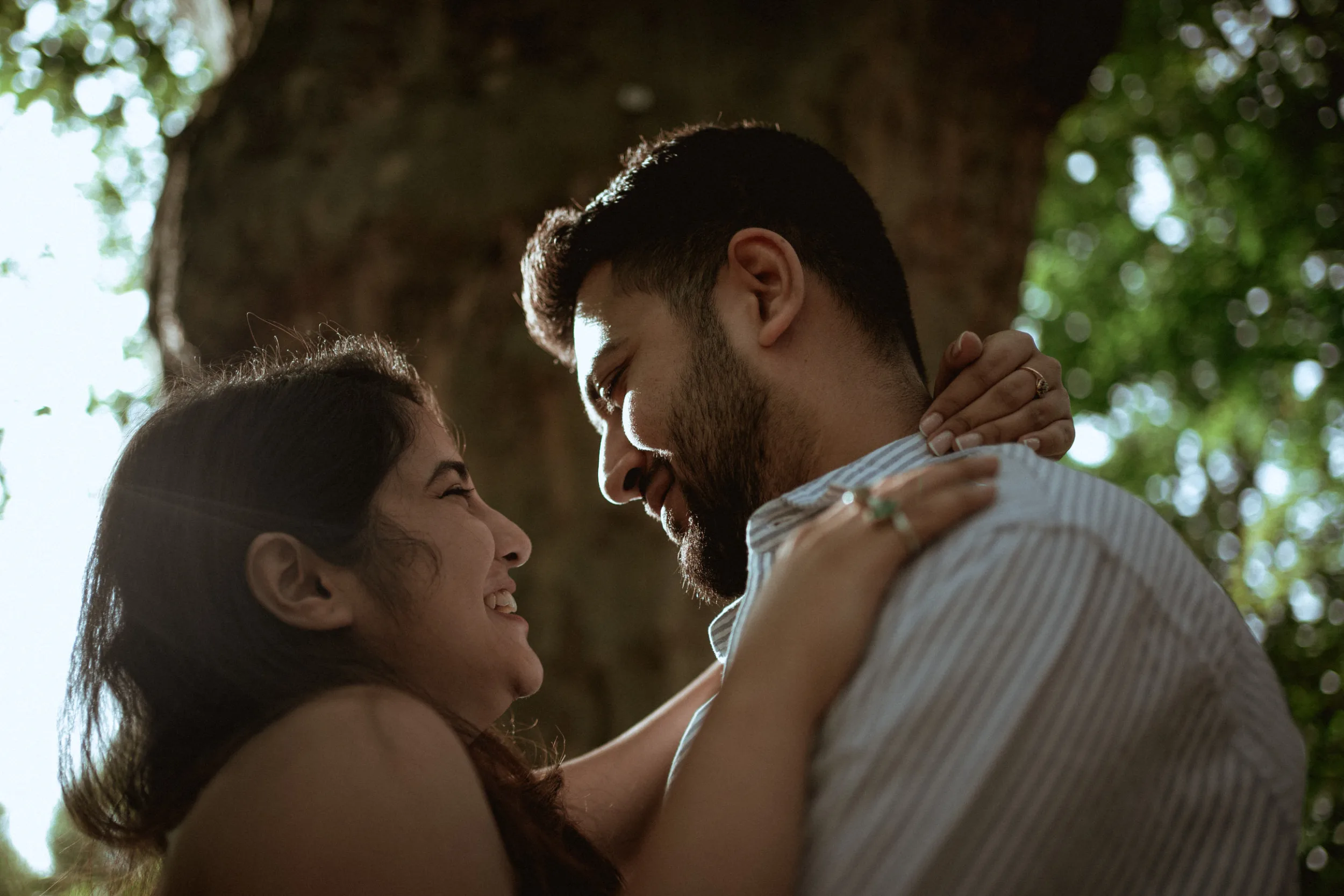 A closeup of a happy couple under a tree on a sunny day