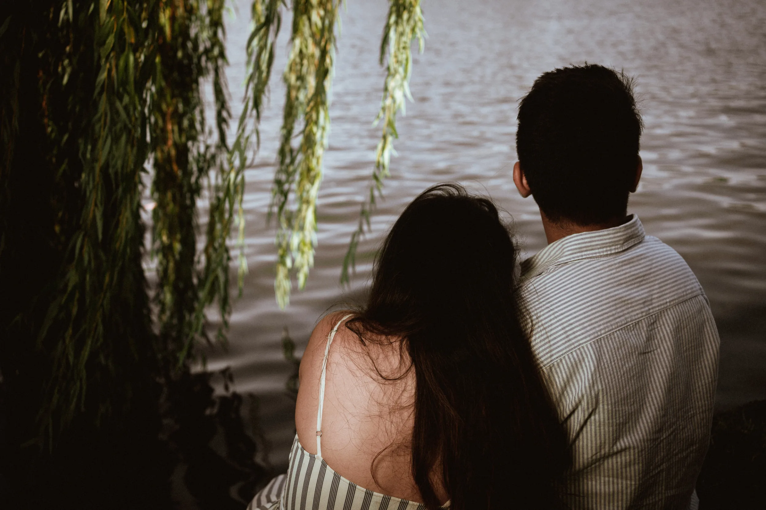 Couple sitting under a tree next to Spree in Berlin